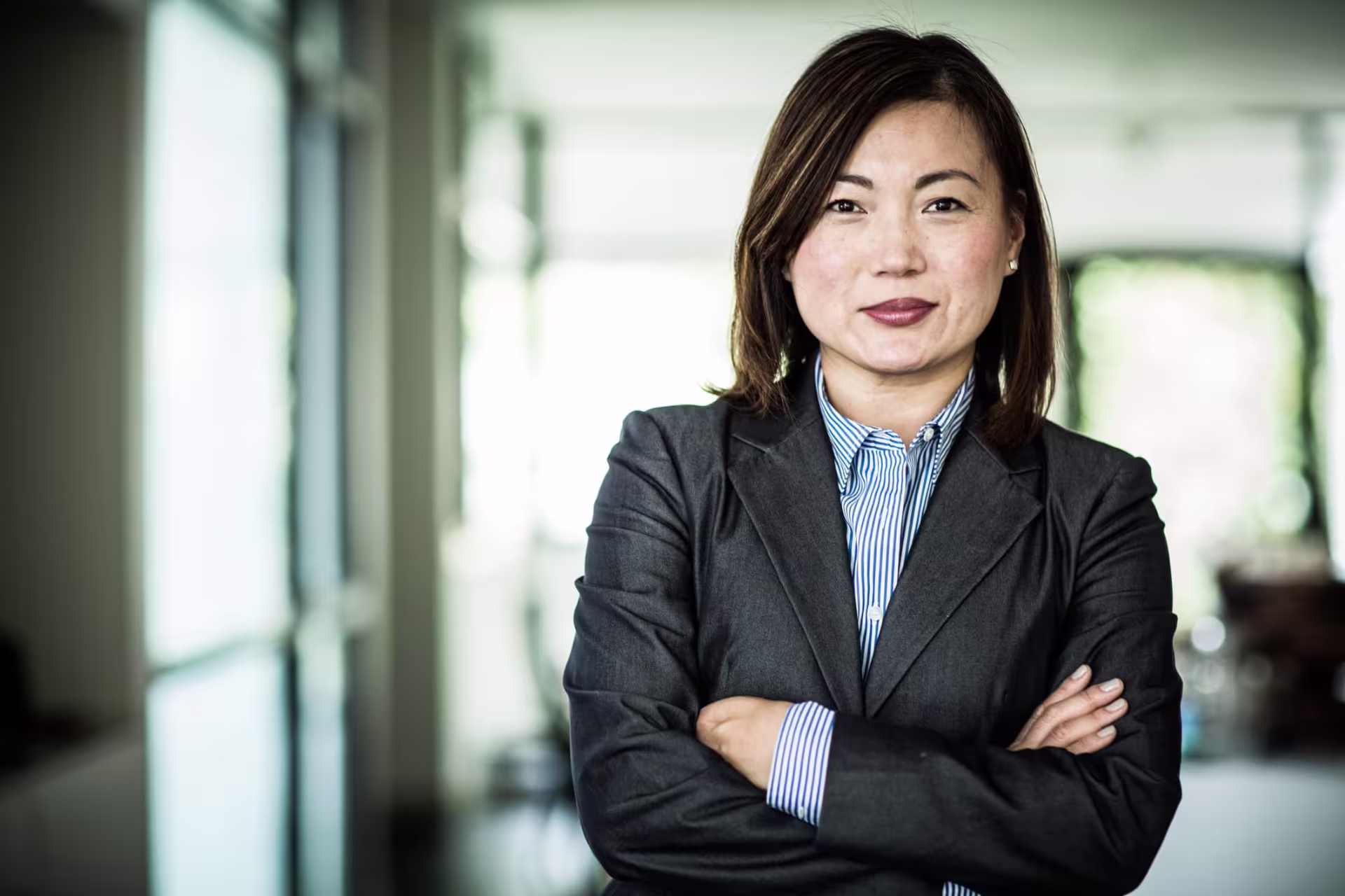 A business woman in a power suit with arms crossed driving innovation and entrepreneurship.