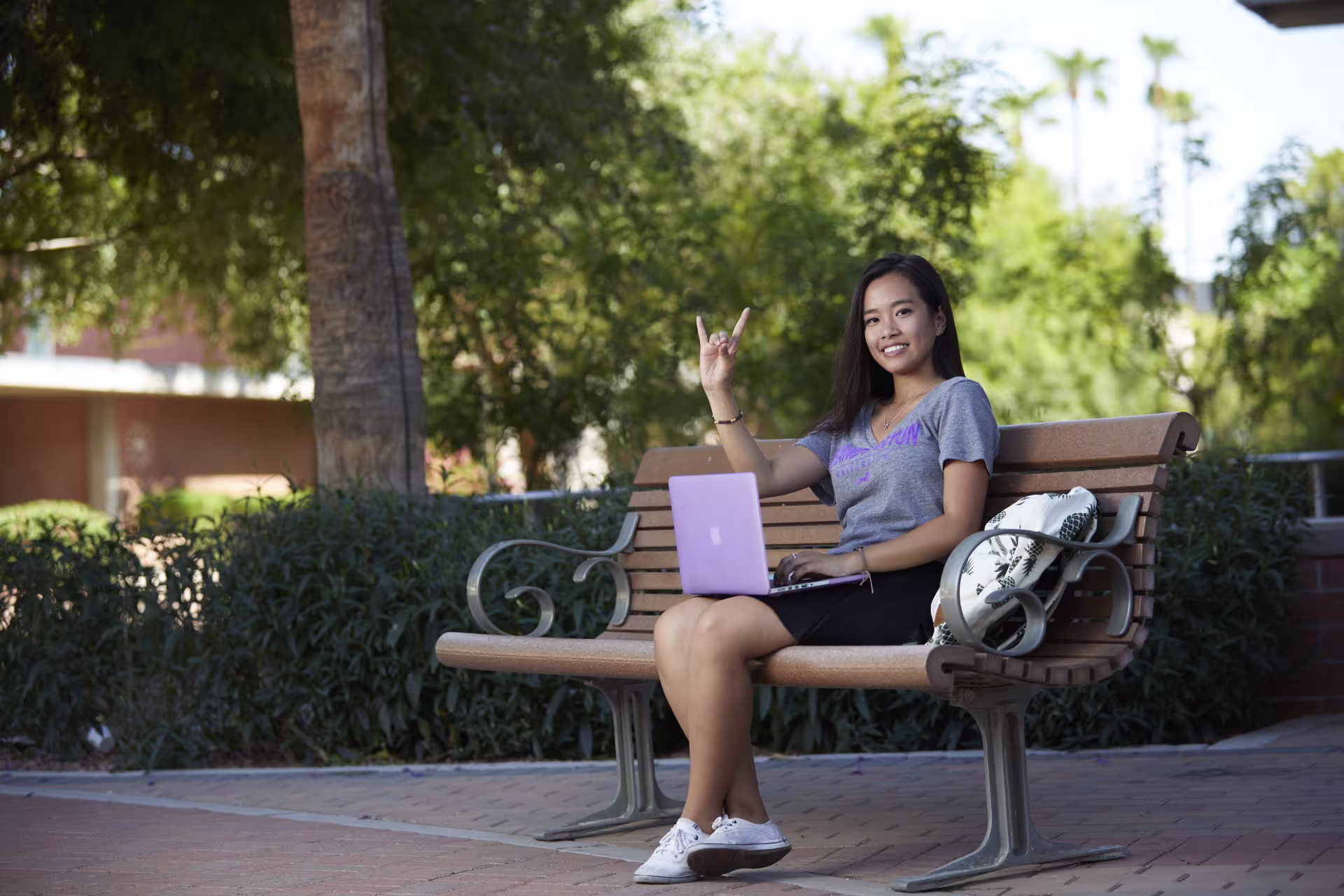Woman sitting on bench researching college scholarships online