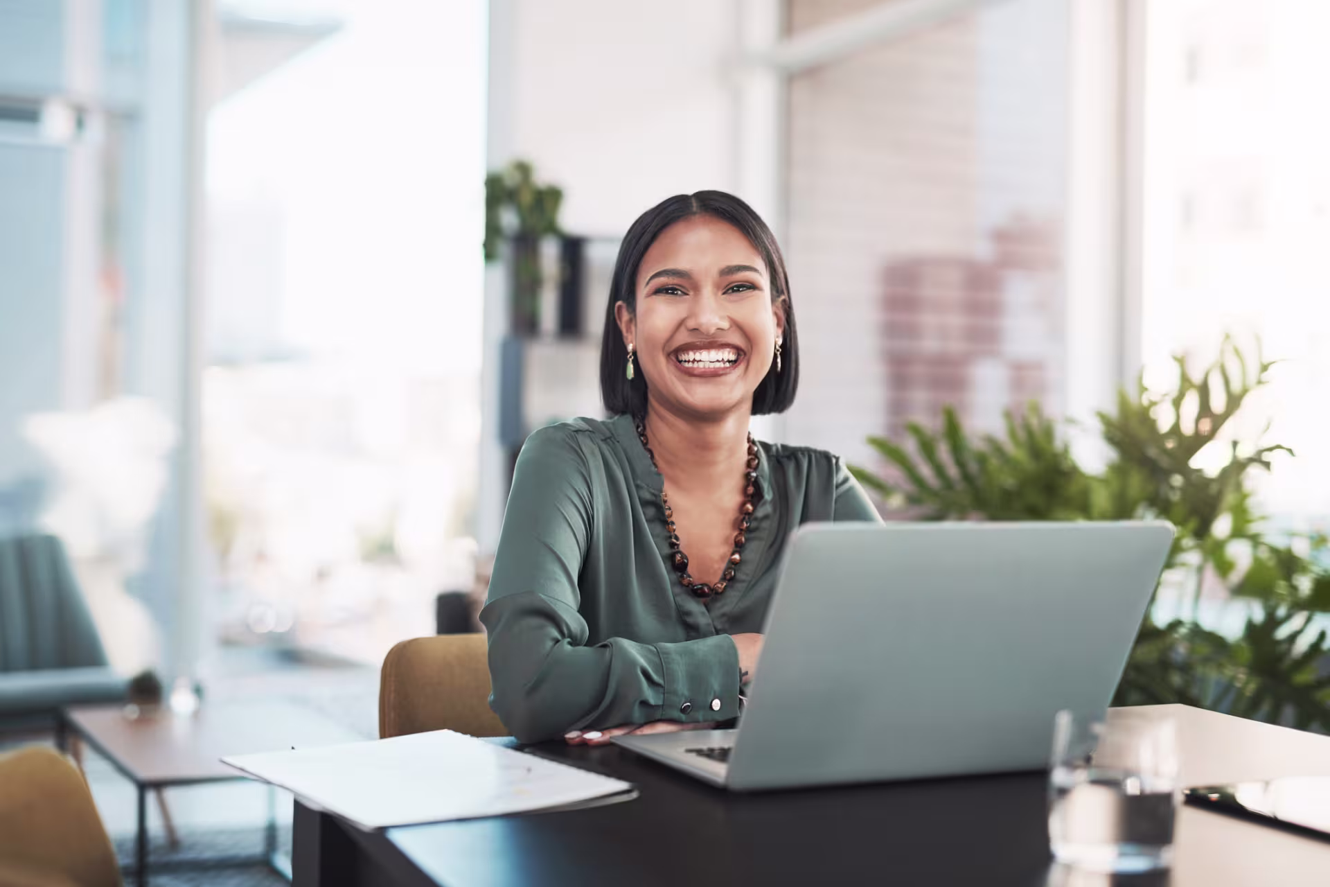 Smiling woman works on online degree on computer
