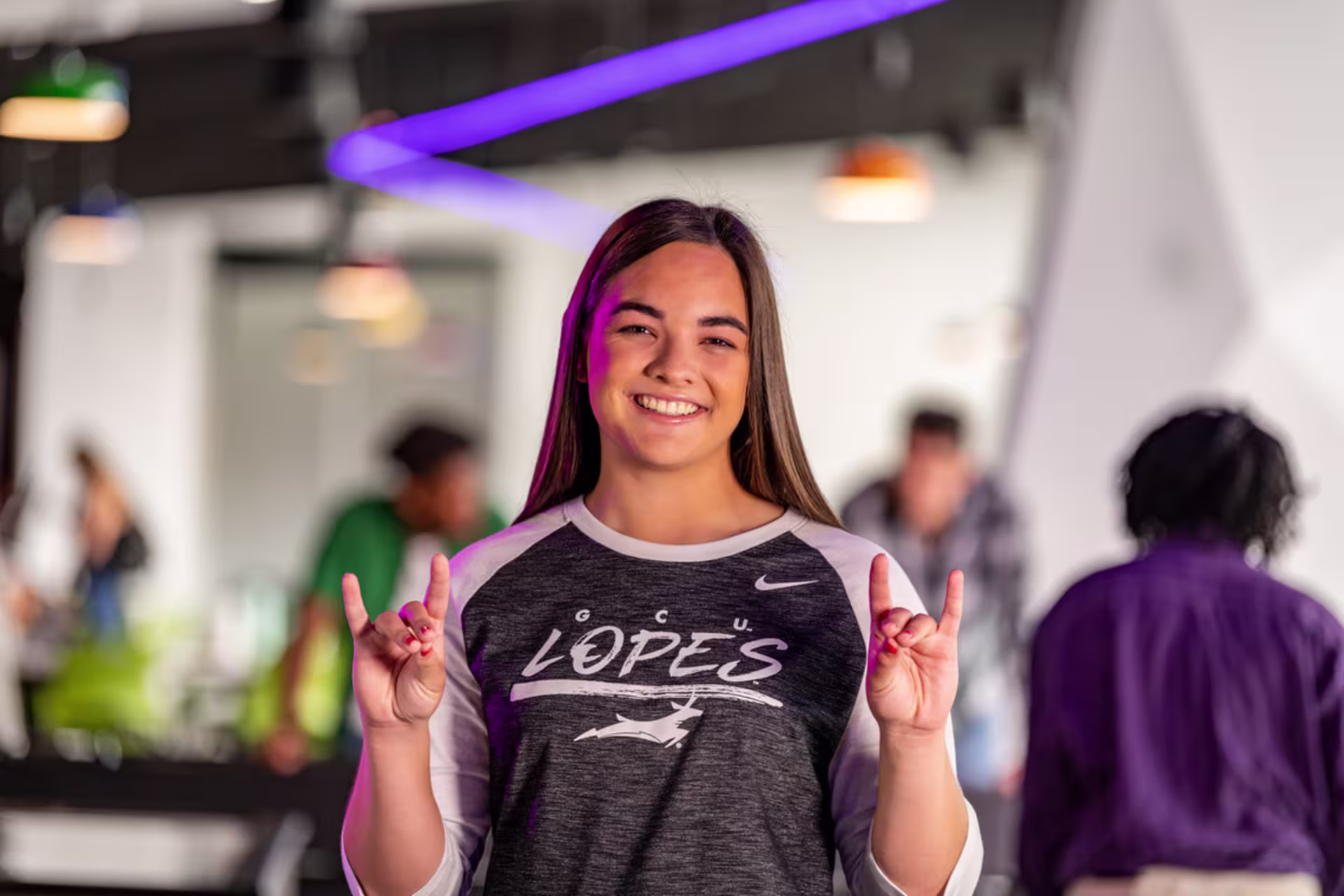 Female student smiling and throwing up Lopes sign.