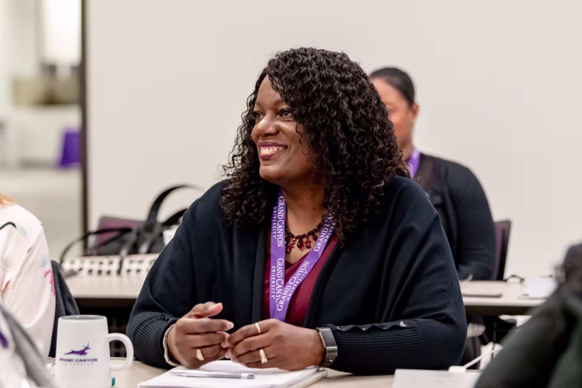 Evening students sitting in class with a coffee mug on the table