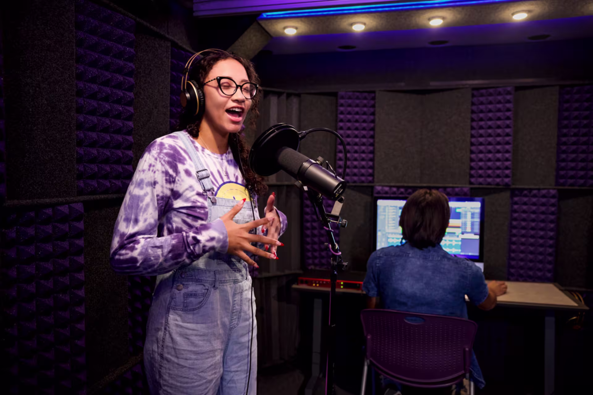 GCU bachelor’s in music student records in studio sound booth with sound engineer