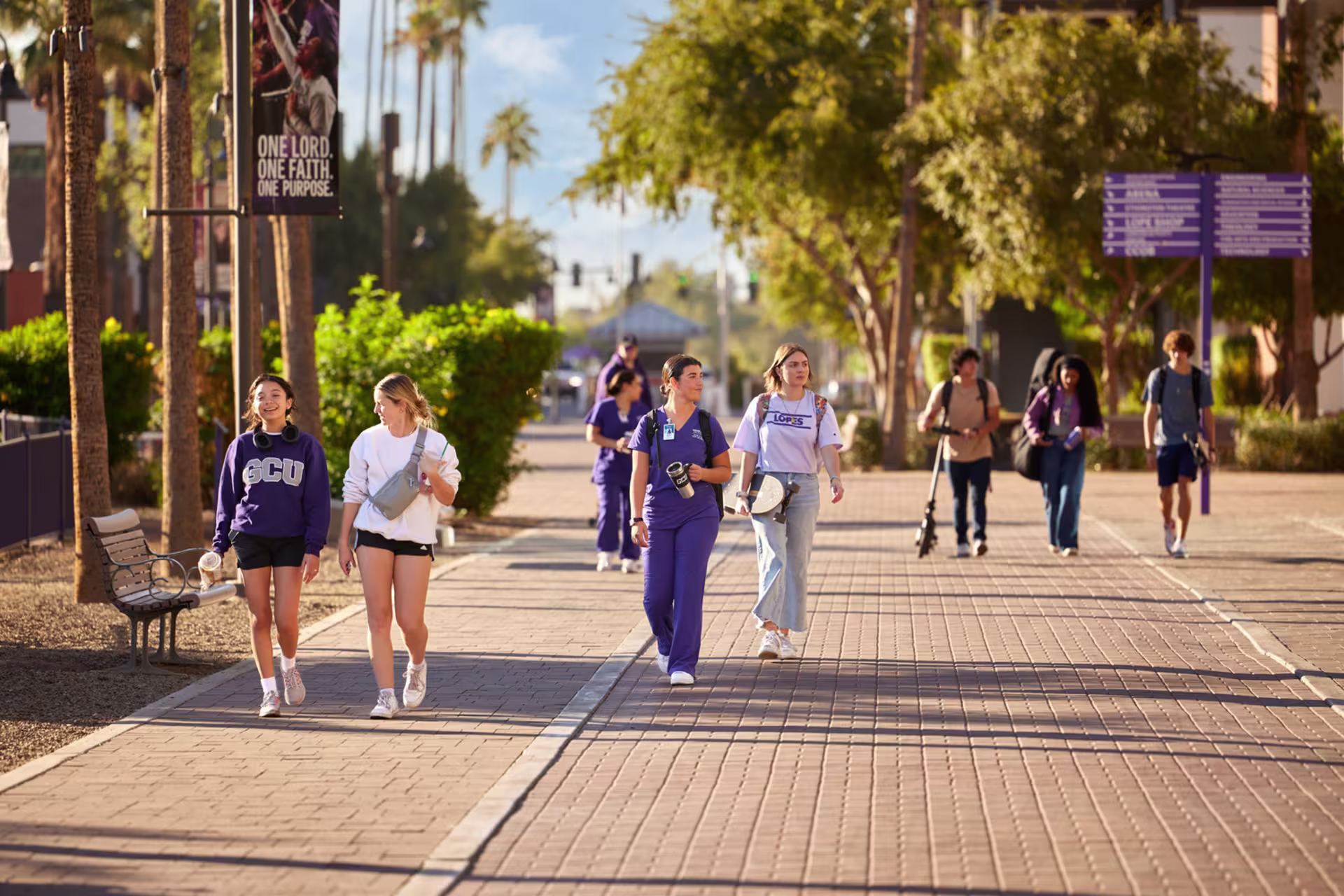 Male and female college students walking in groups on campus.
