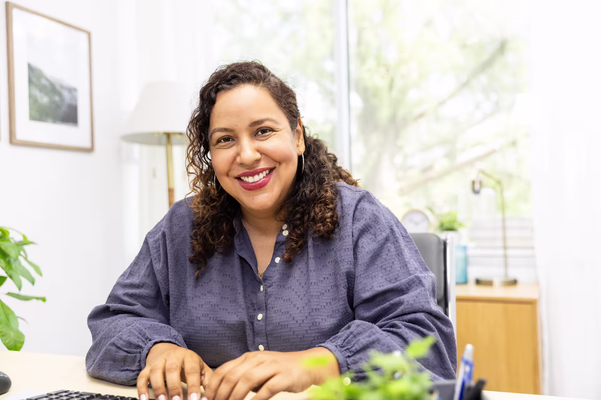 principal sitting at her desk smiling