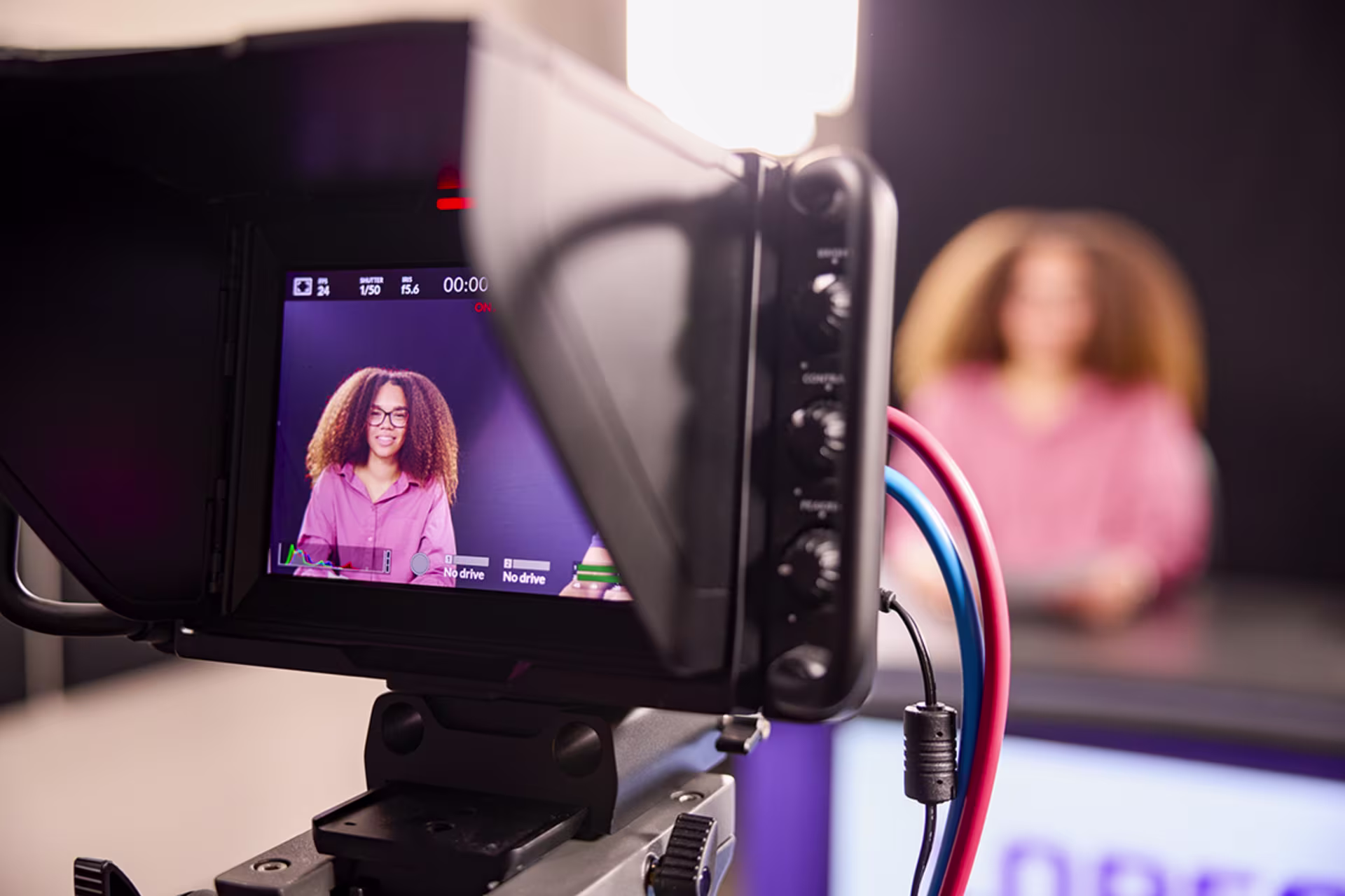 Focused shot of video camera filming female student