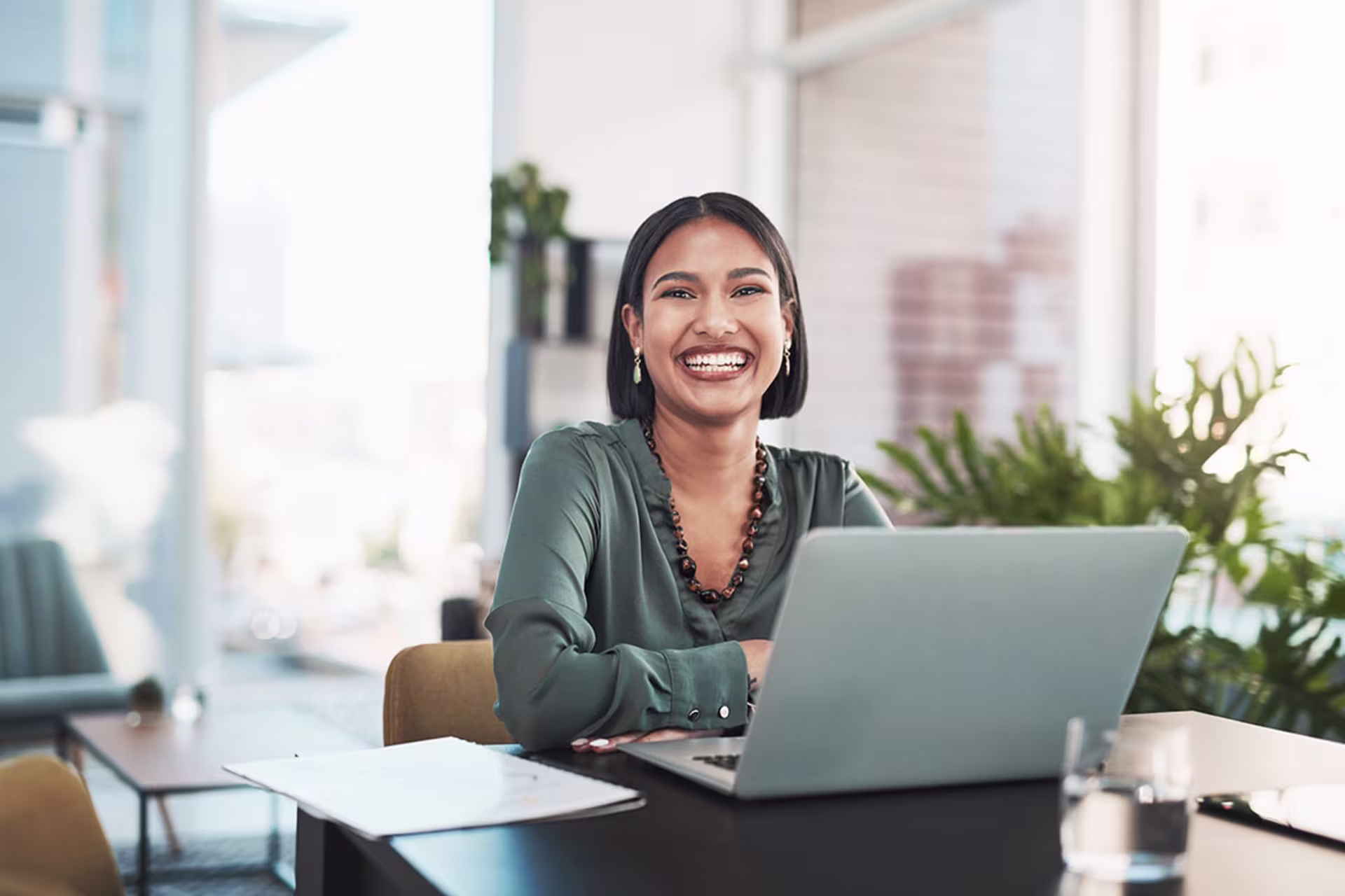 Smiling woman works on online degree on computer