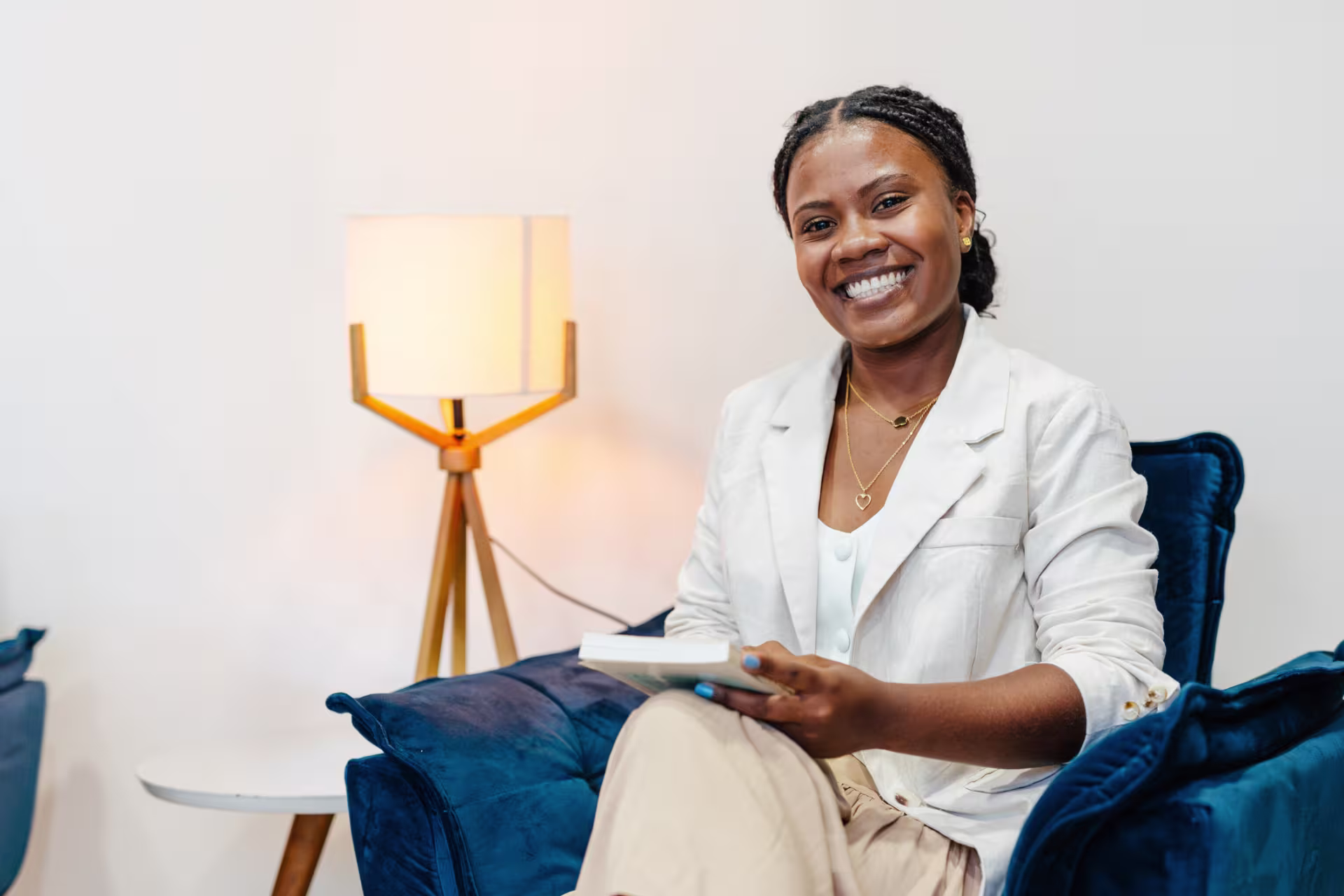 Psychiatrist smiles from her office chair with a notebook in hand.