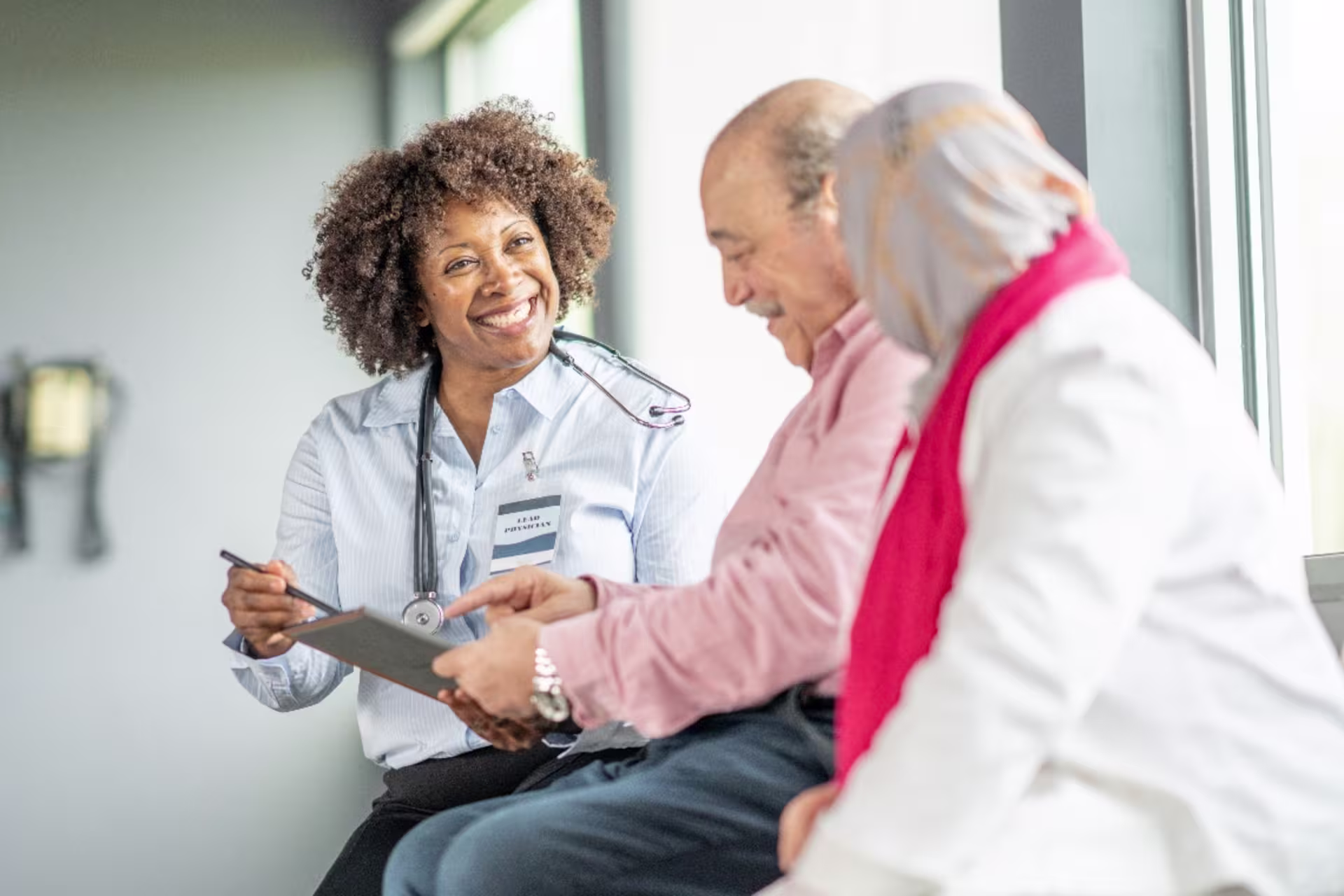 Female BS in BHS major conversing with patients while holding a clipboard.