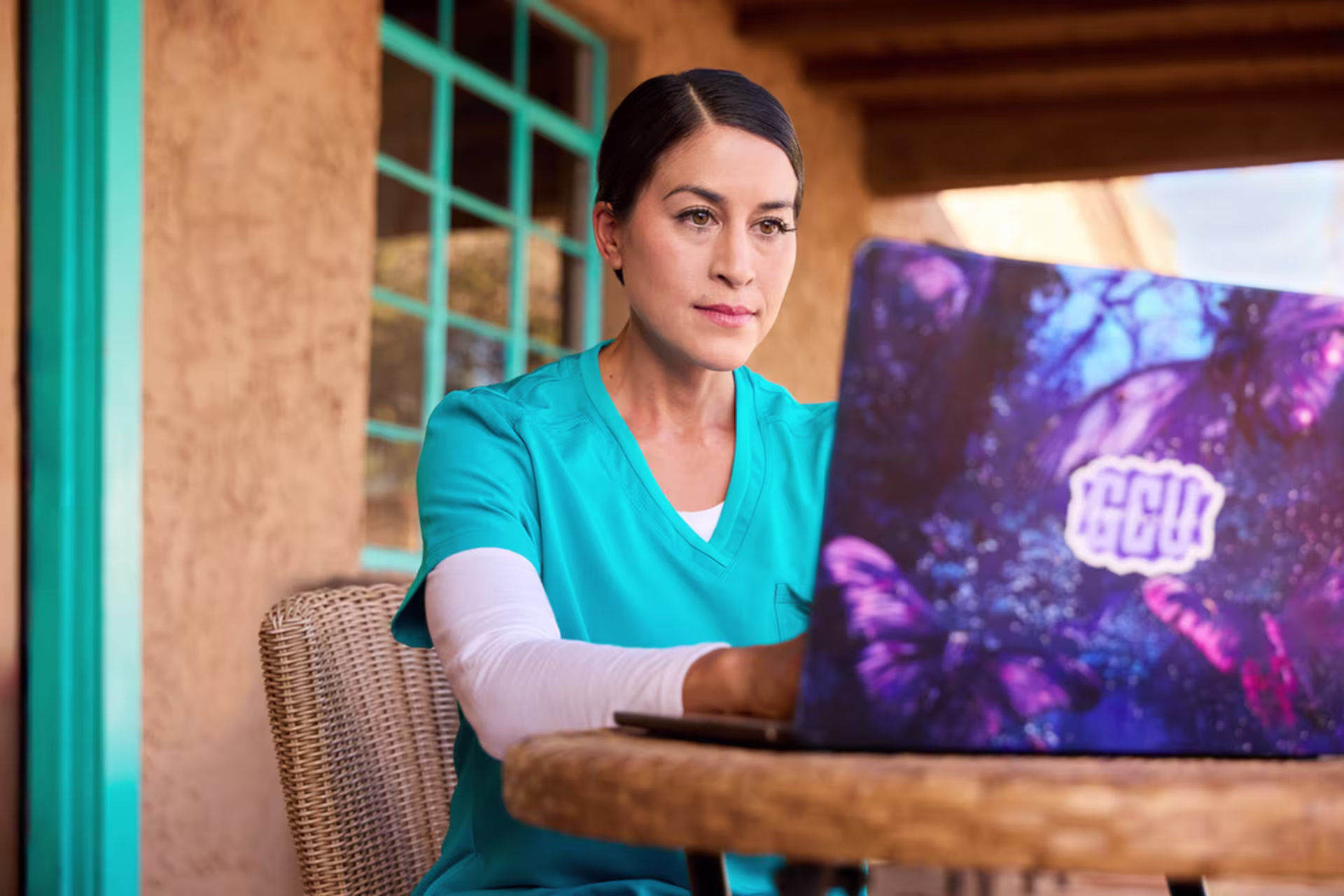 Health informatics nursing student working on a laptop while studying in an outdoor setting.