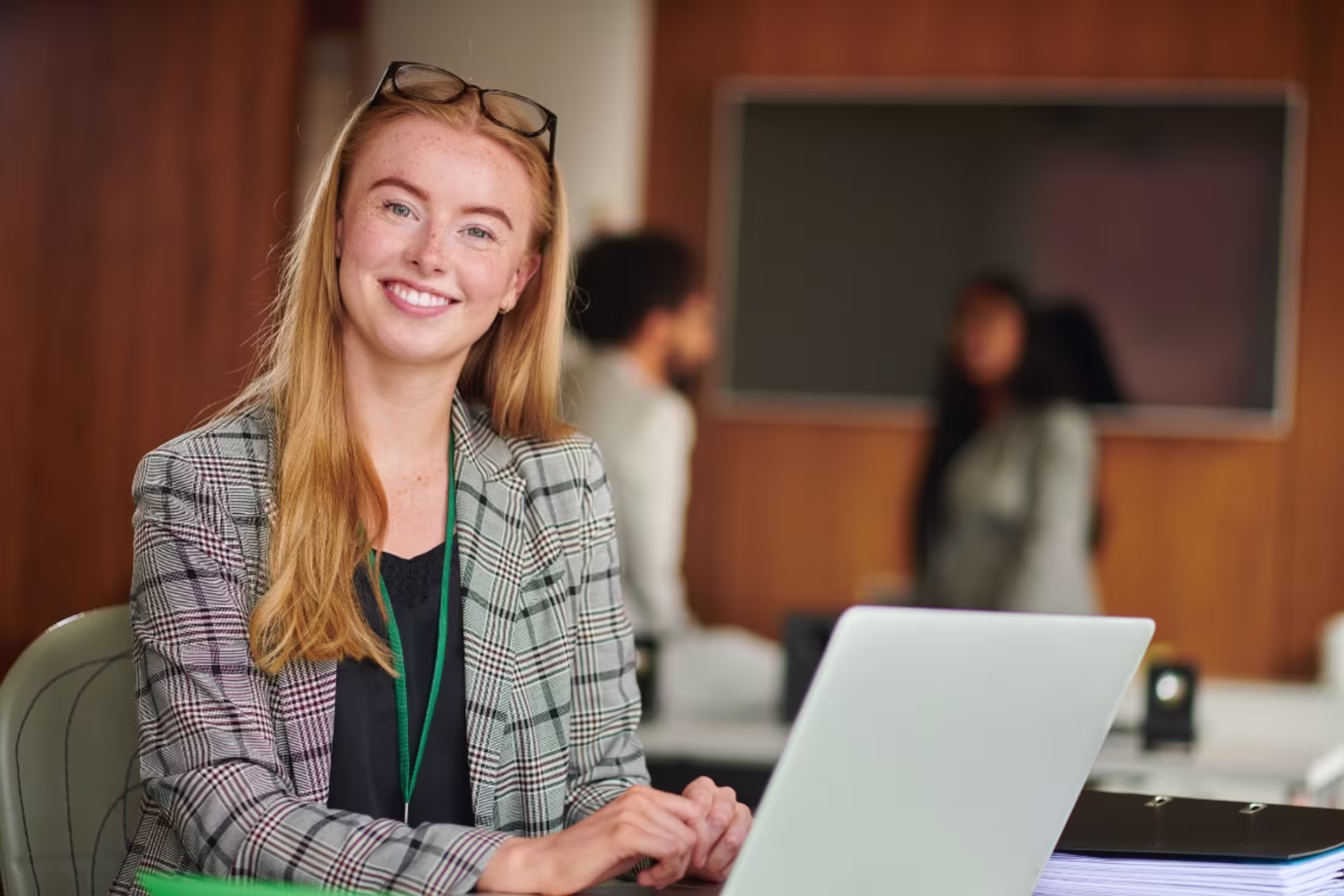 A project management student works on a laptop in a professional office setting.