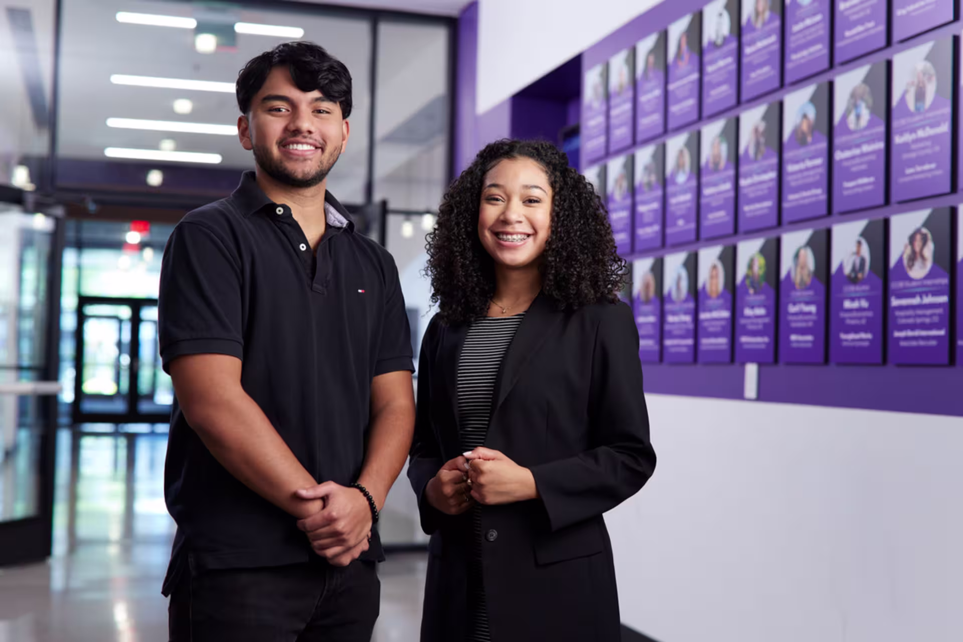GCU human resource management students smiling at camera in hallway.