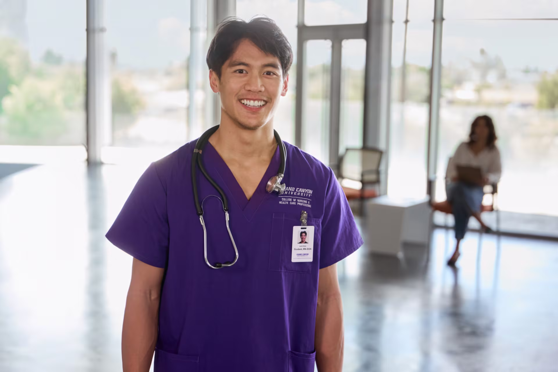 A male nursing student stands confidently in a healthcare facility.