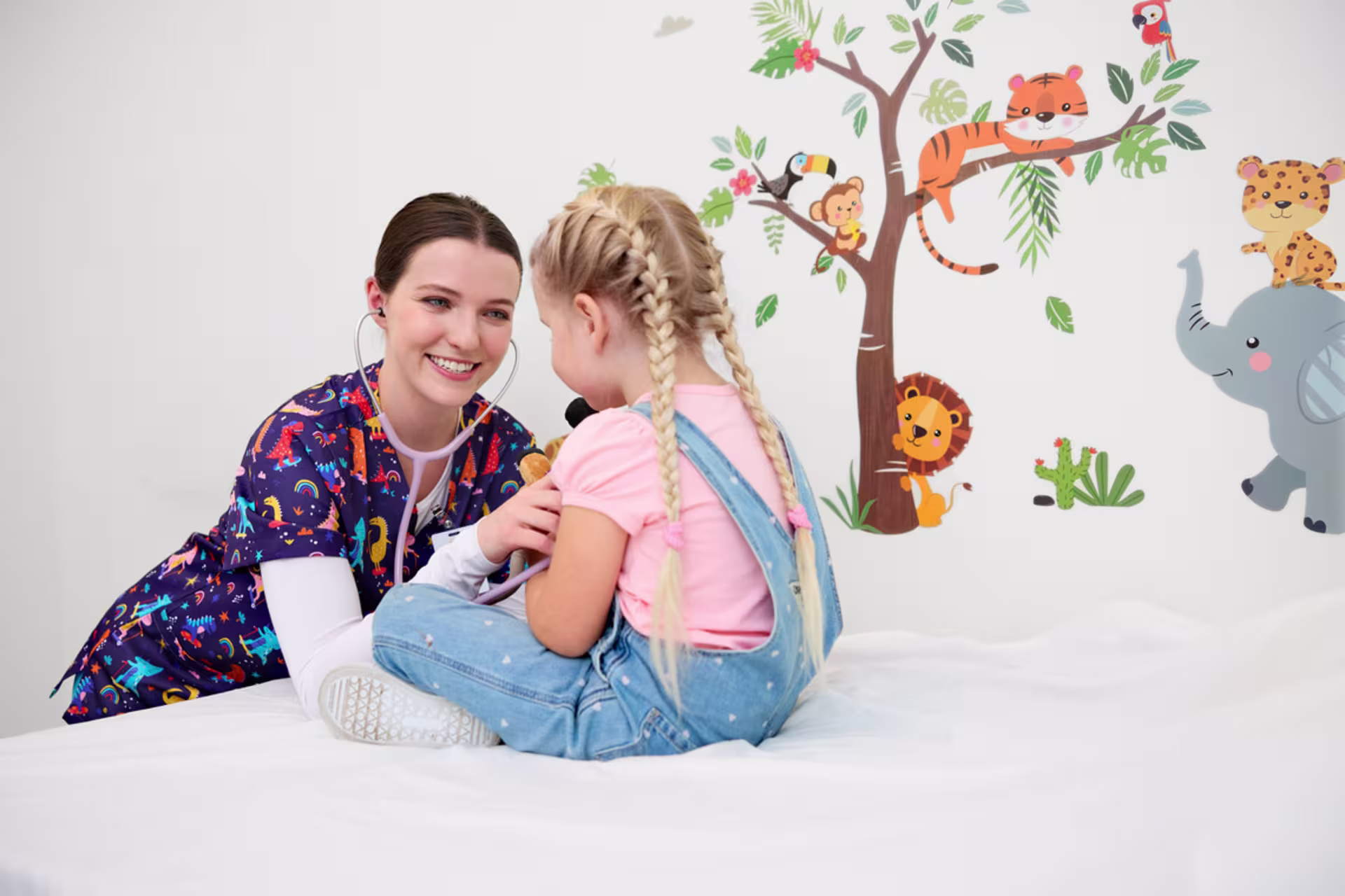 A female pediatric nurse examines a young child during a wellness visit.