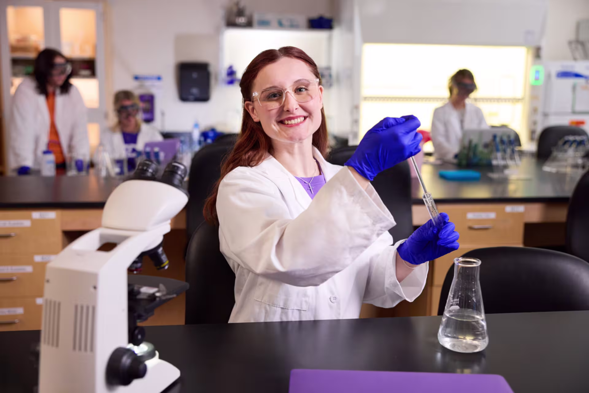 A female chemistry degree student uses a pipette during a laboratory experiment.