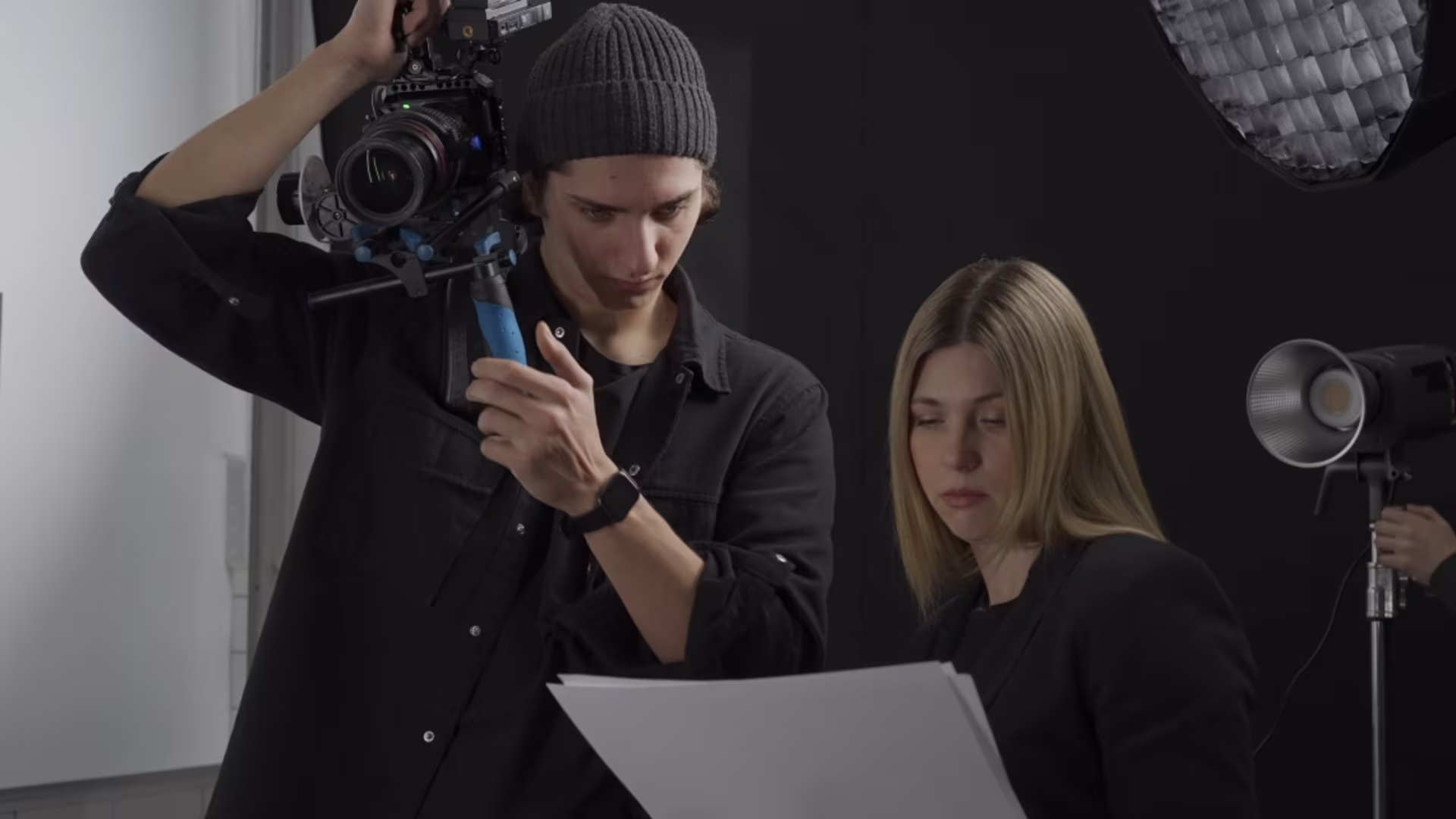 A screenwriter reviews script pages with a camera operator during a film production.