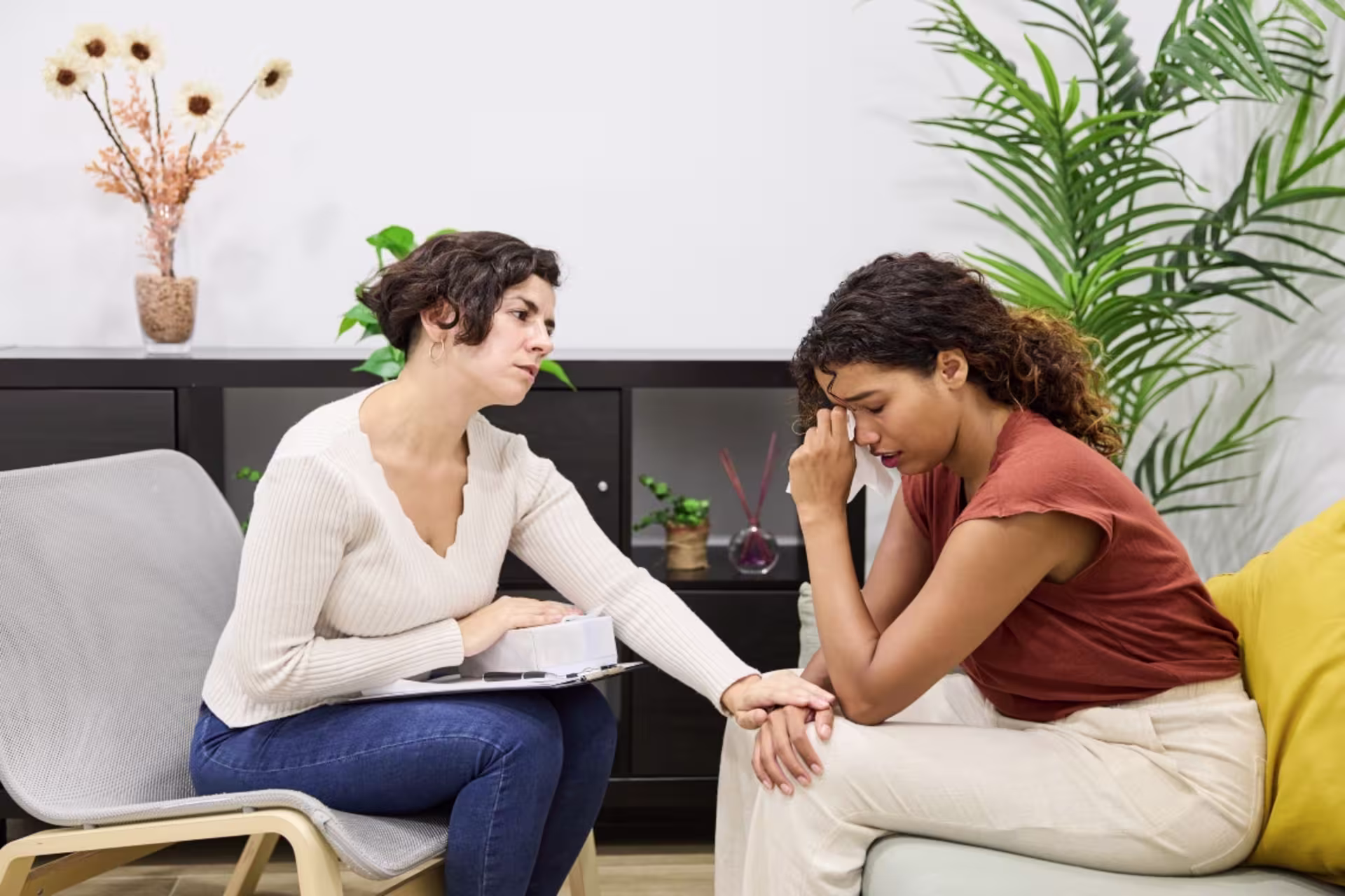A female grief counselor provides compassionate support during an individual counseling session.