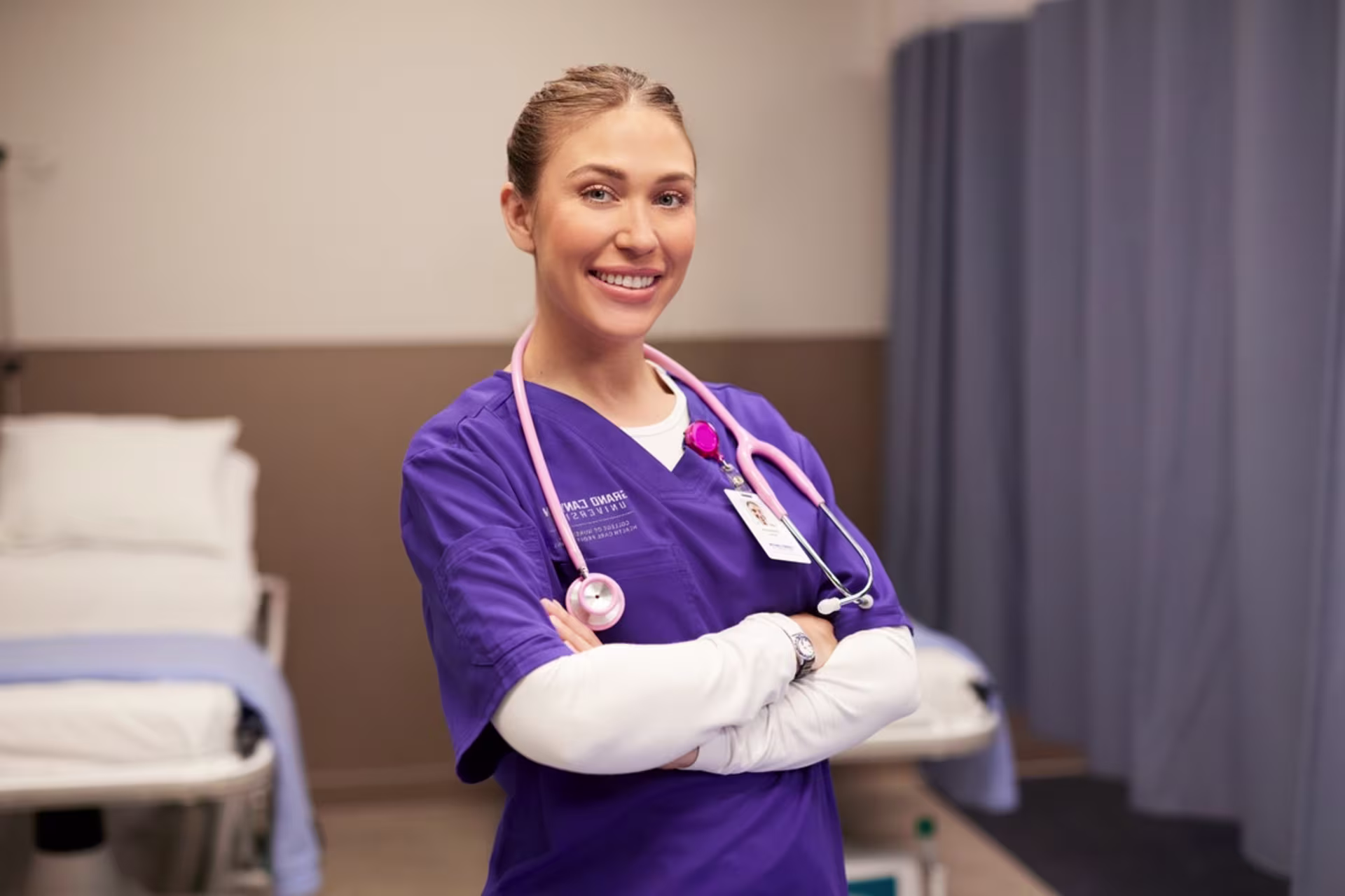 Female GCU ABSN student in nursing scrubs with a stethoscope in a clinical setting.