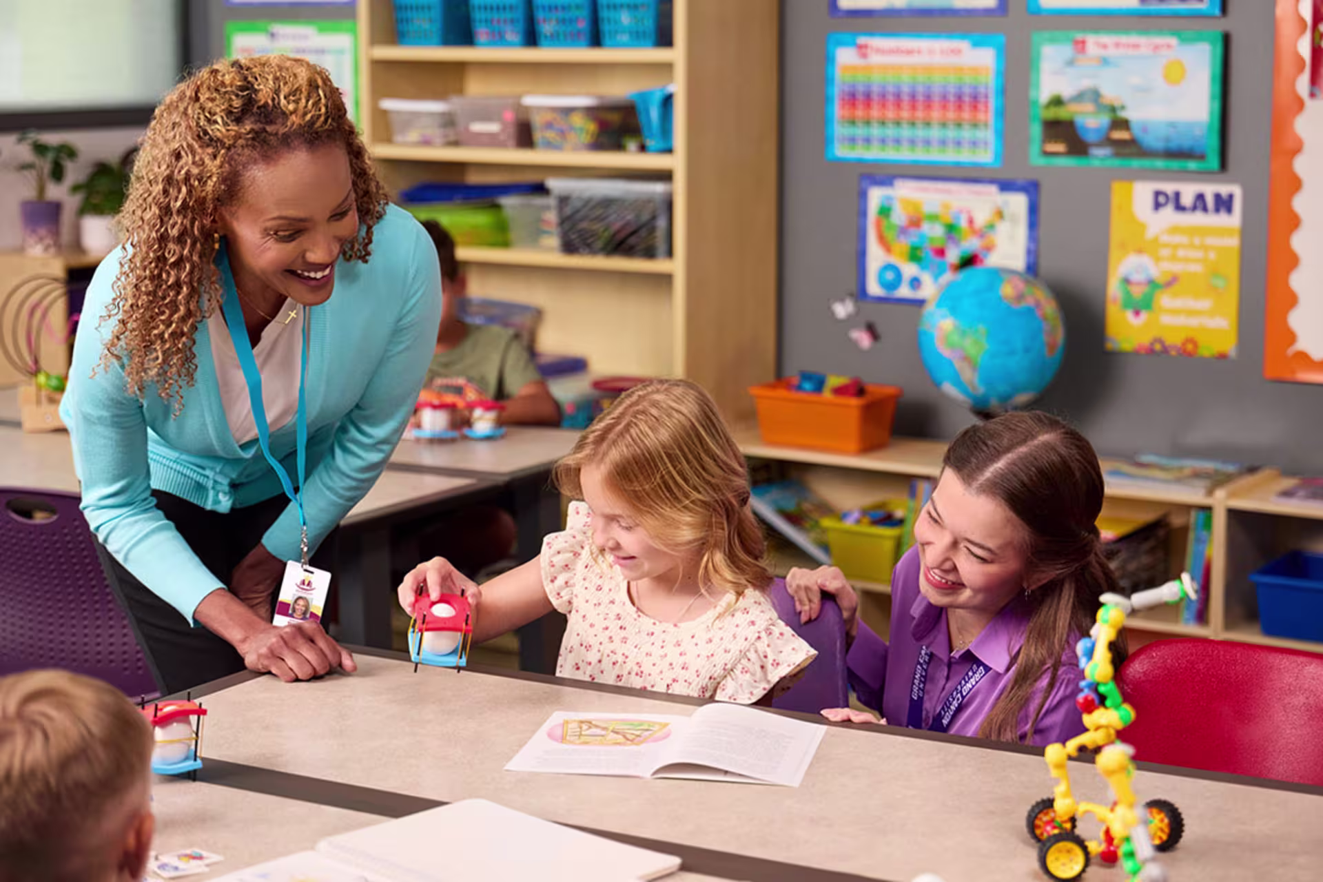 Teacher engaging with young students in a classroom during an interactive learning activity.