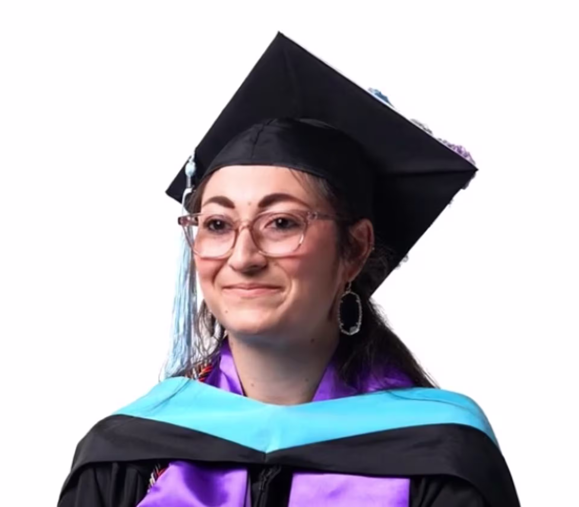Jessie Hickey wears a black graduation cap and gown with a light blue academic hood, purple stole, honor cords, and glasses, posed against a plain light-colored background.