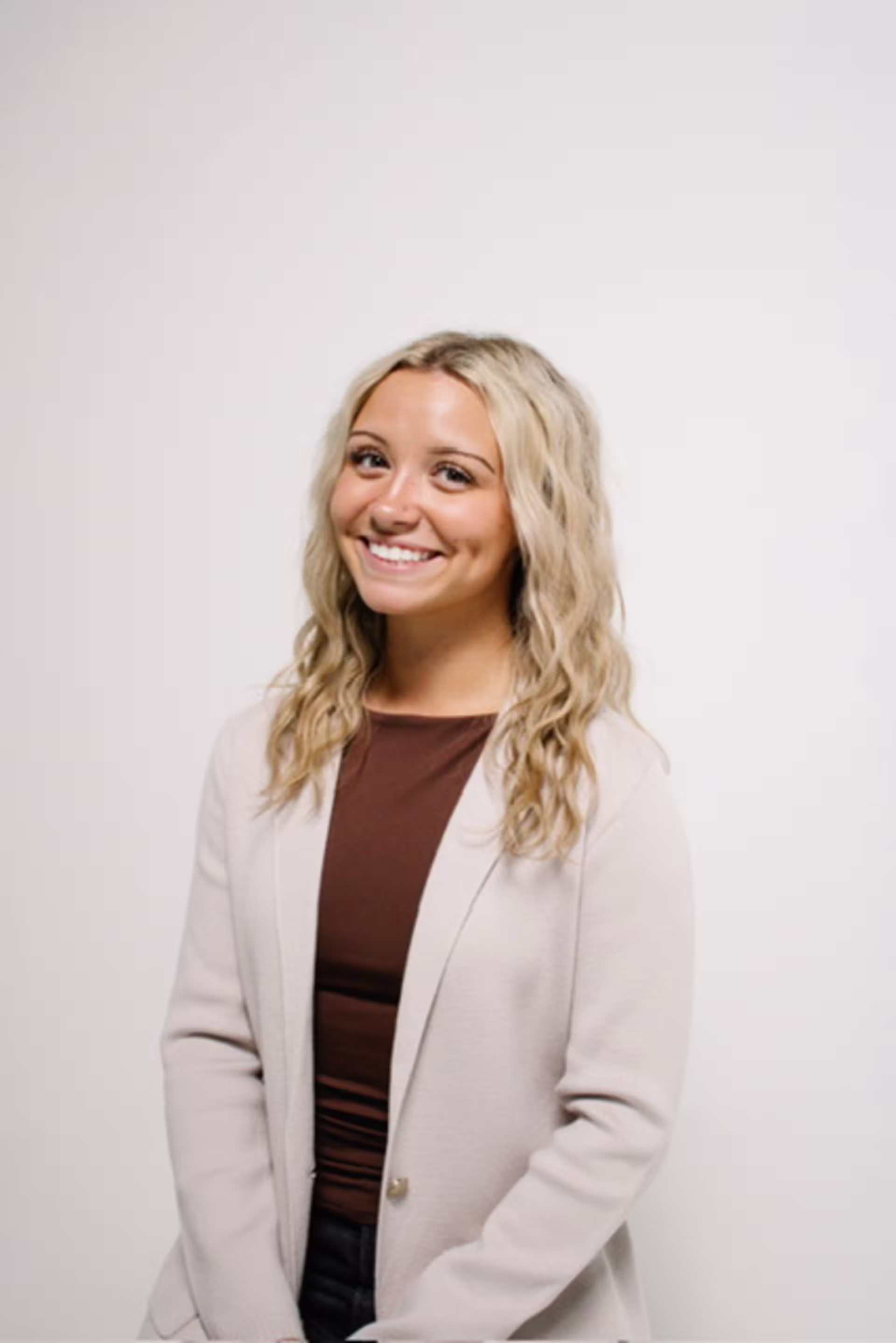 Headshot of Kate Weeber, a 2027 new media graduate, standing against a neutral background in a light blazer.