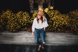 riley parsons sitting by flowers.
