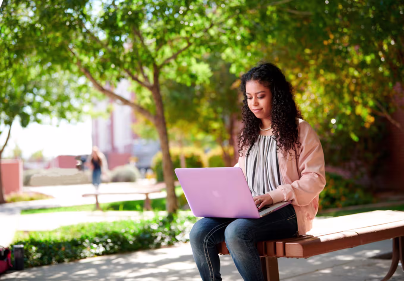 Digital Design Student Sitting Outside and Working on Laptop