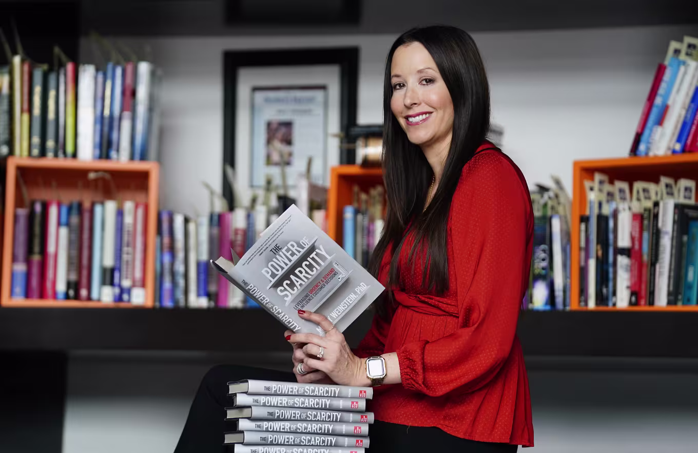 Mindy Weinstein sitting in office with stack of books she authored