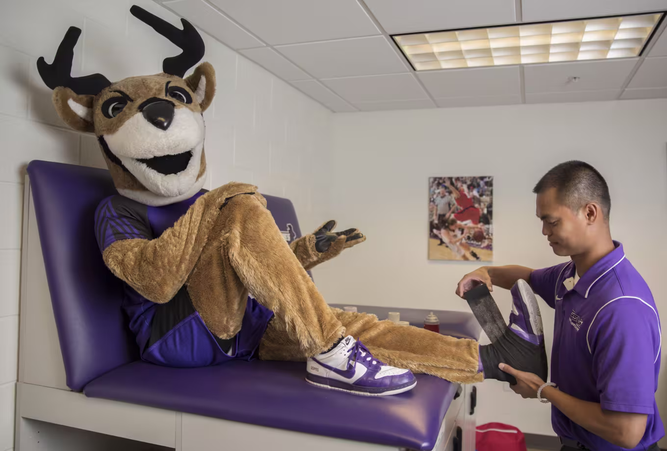Male athletic trainer assessing Thunder’s foot