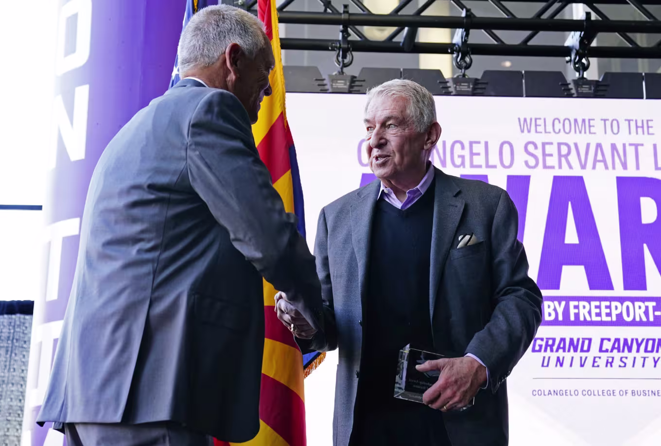 Jerry Colangelo and recipient shaking hands at GCU awards event