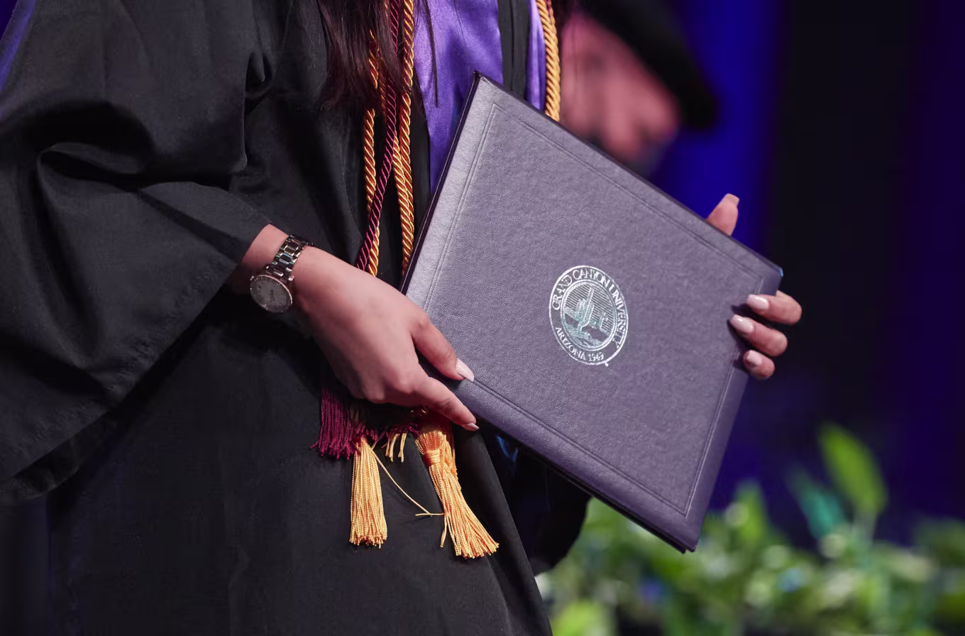 Close-up image of graduate holding GCU diploma