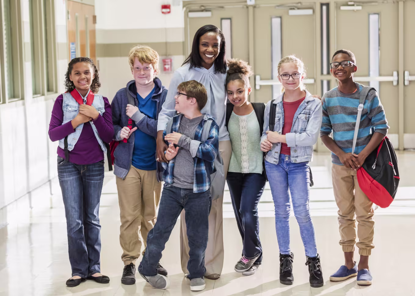 female teacher standing with students in hallway