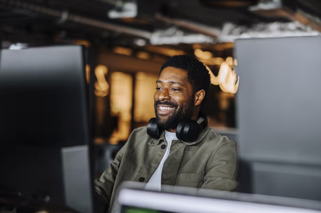 Computer science employee smiles at desk