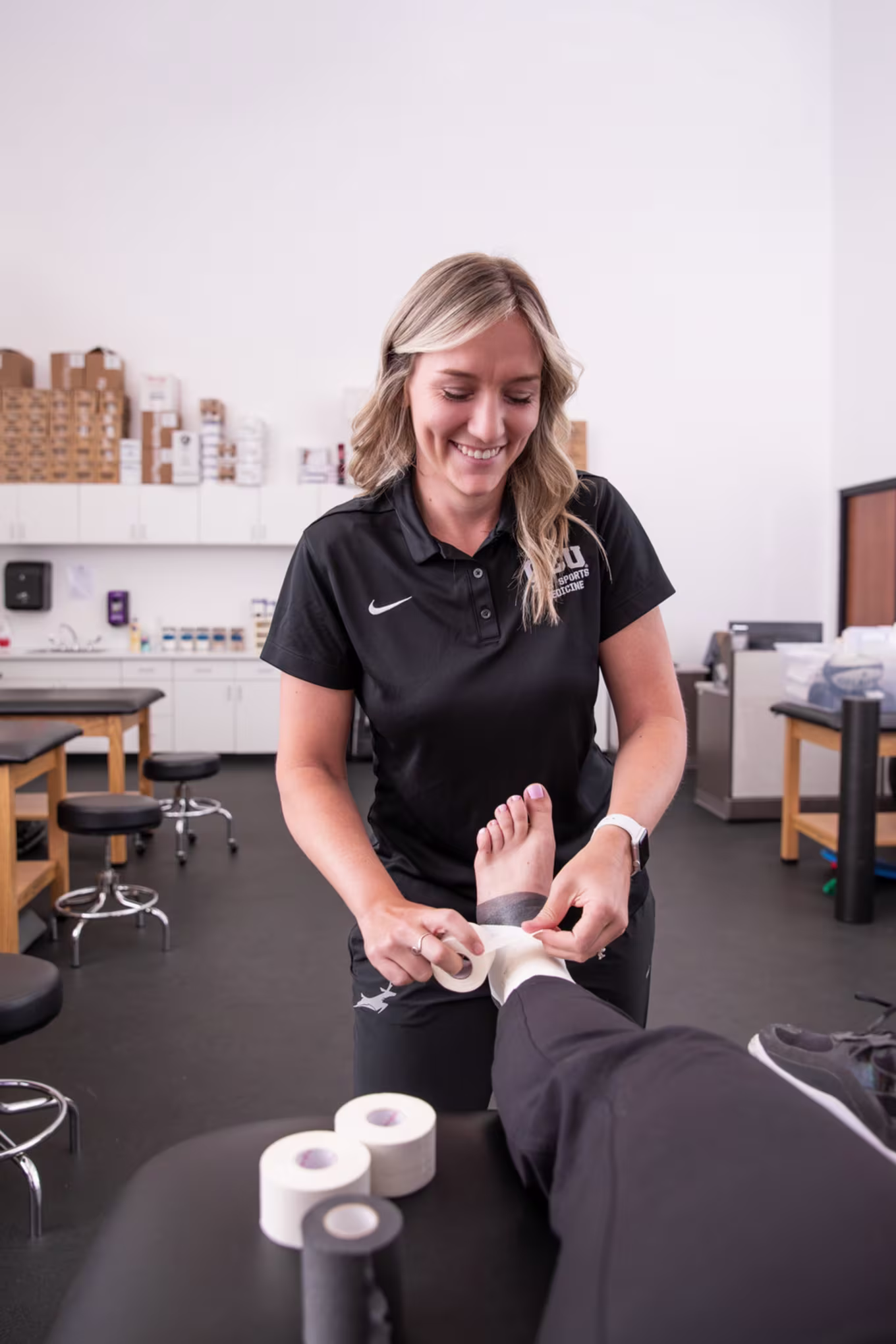 GCU student wrapping athletes ankle in pre-physical therapy training