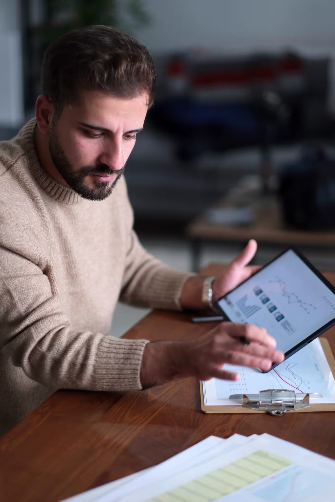 A DBA student studying data analytics on a tablet and printed reports.