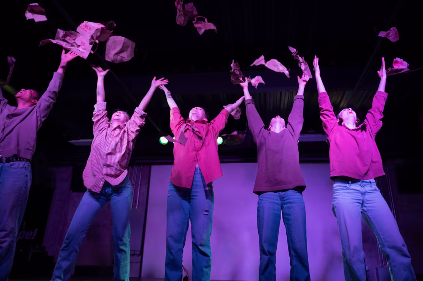 A group of arts and media dance students putting on a performance on stage.