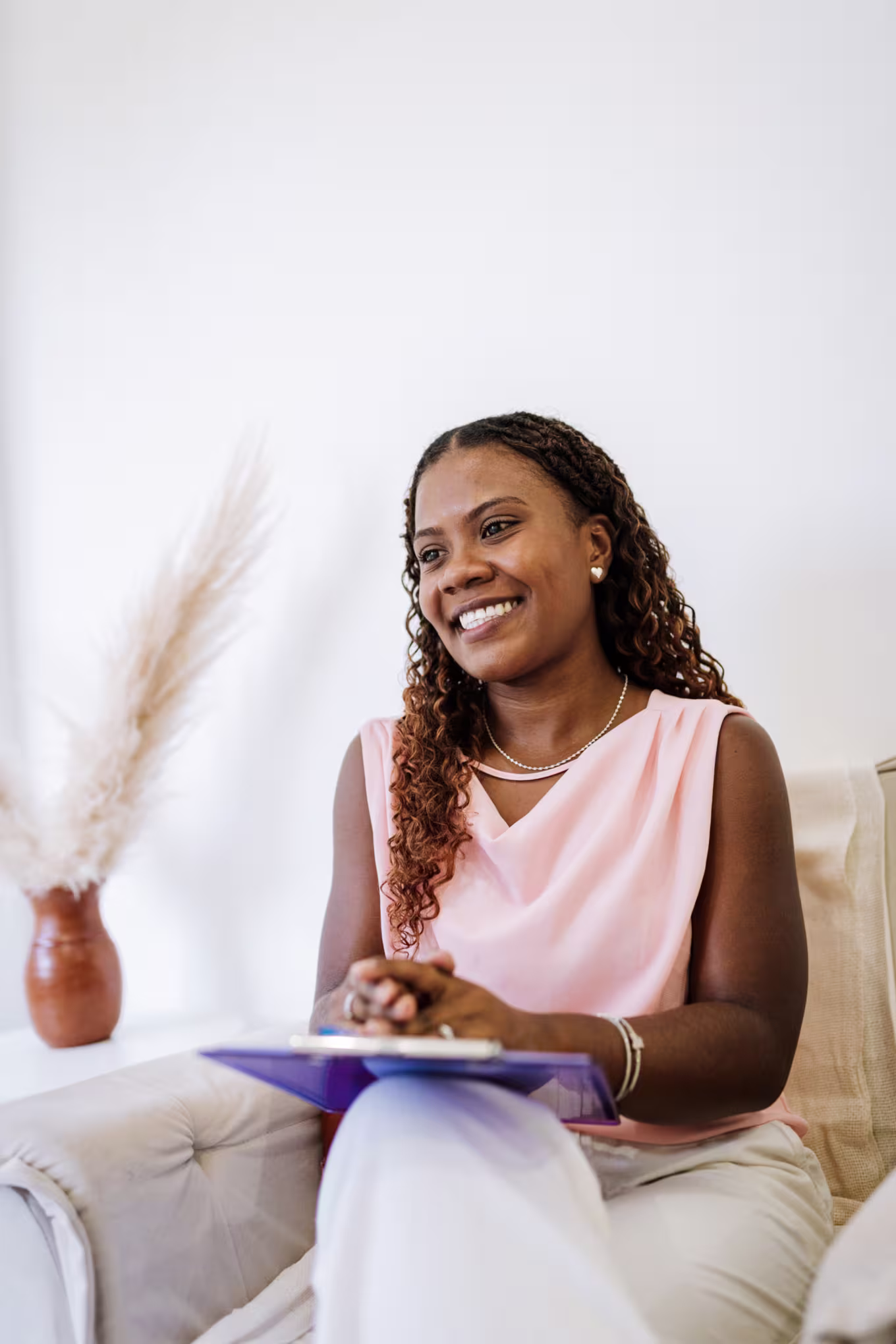 young black female therapist smiles with clipboard on lap