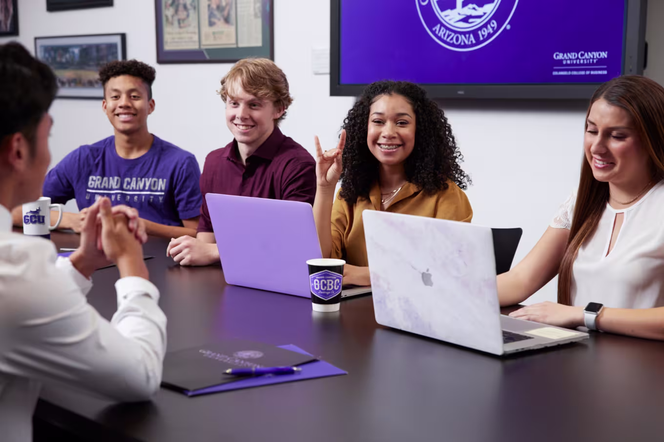 Male and female business majors in tutoring session working on laptops