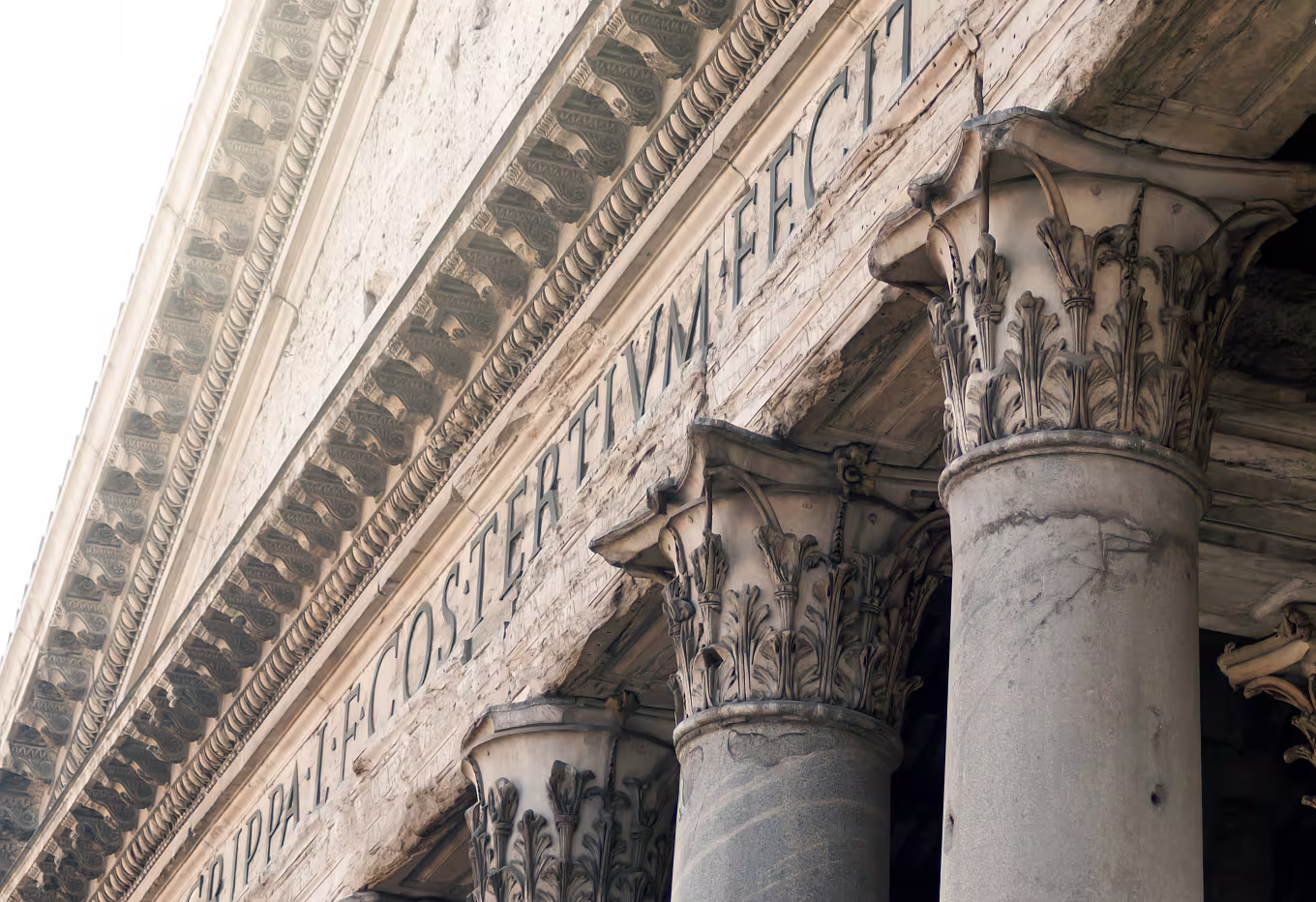 Three Greek courtroom pillars underneath inscription.