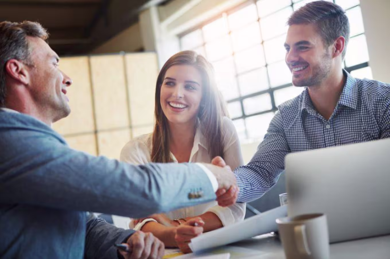 three people meeting and shaking hands