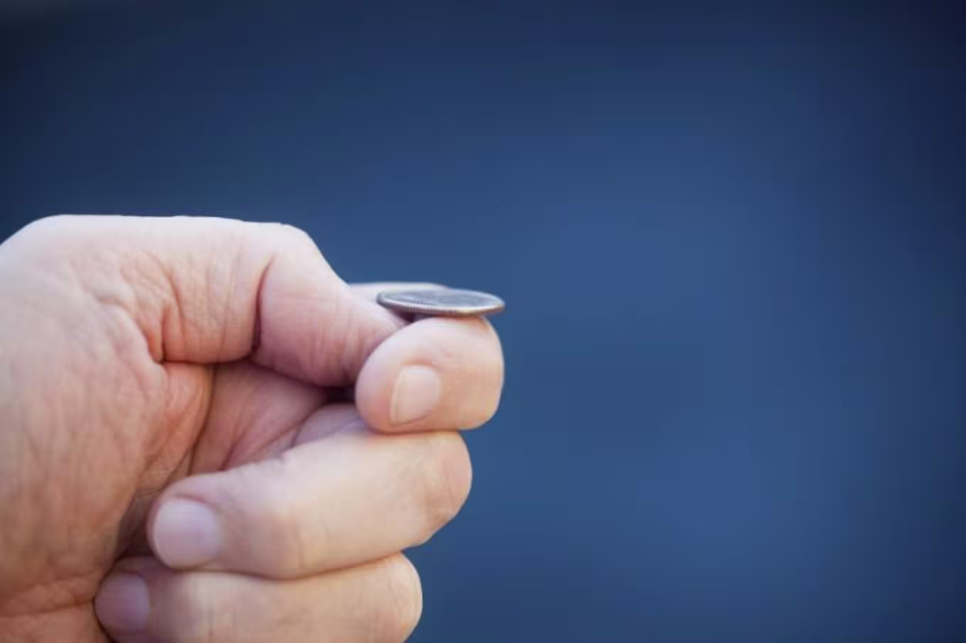 hand balancing a coin