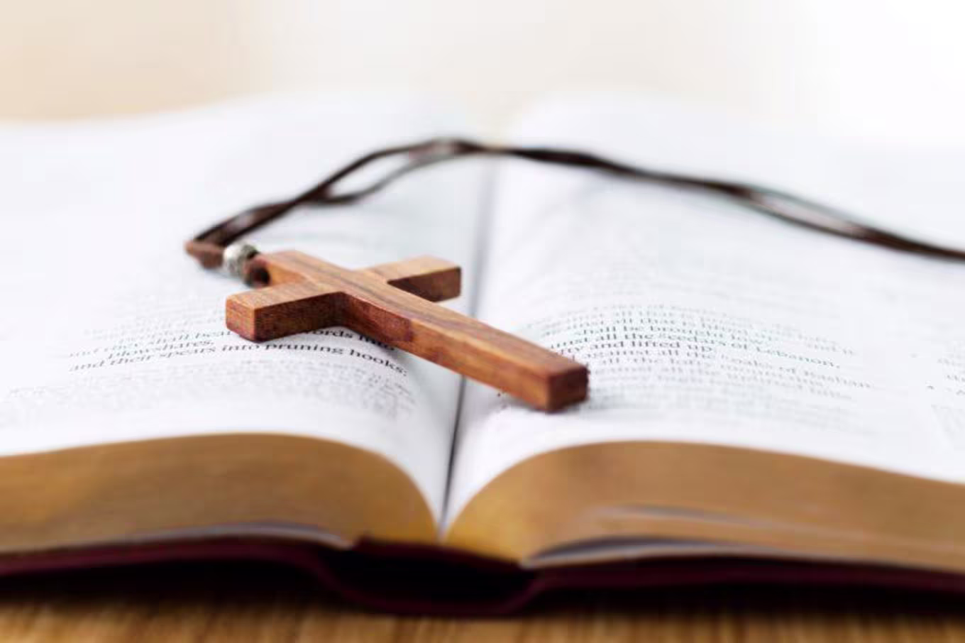 bible with a cross necklace sitting on top