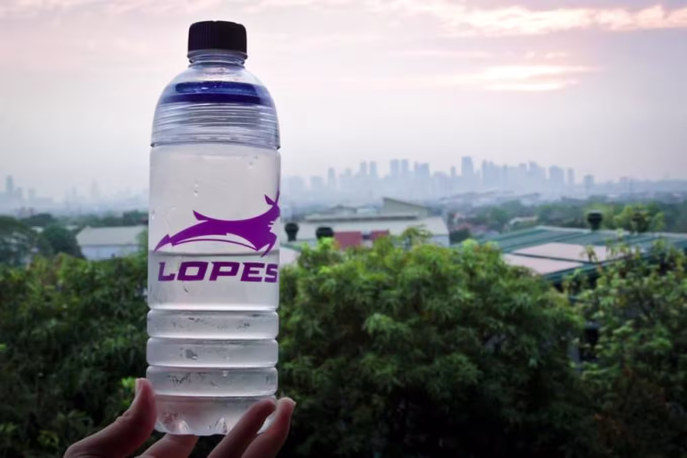 Lopes water bottle shows Philippines landscape in background