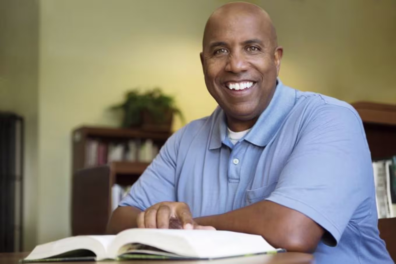 Adult man reads book at table
