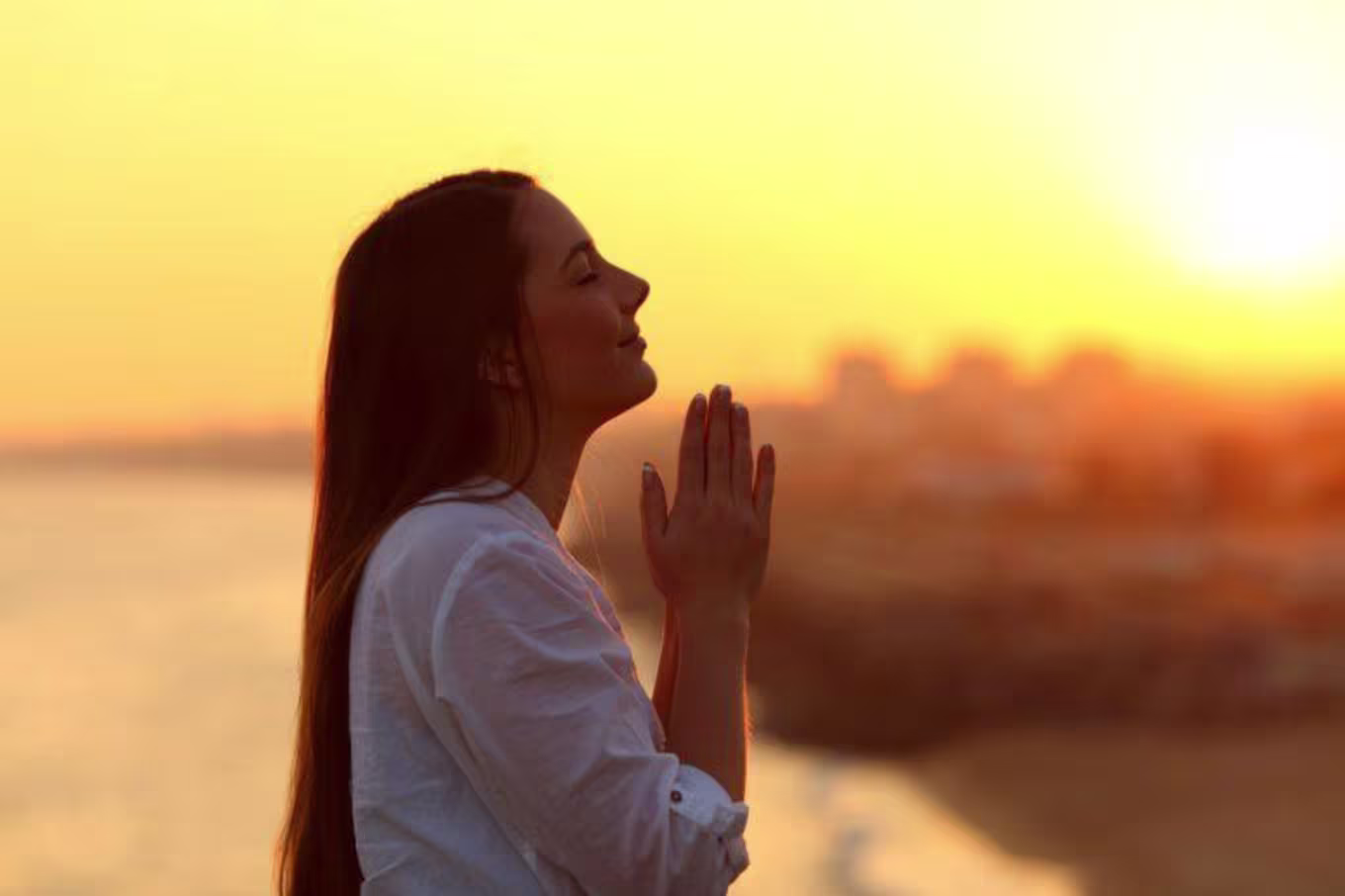 woman praying during sunrise or sunset