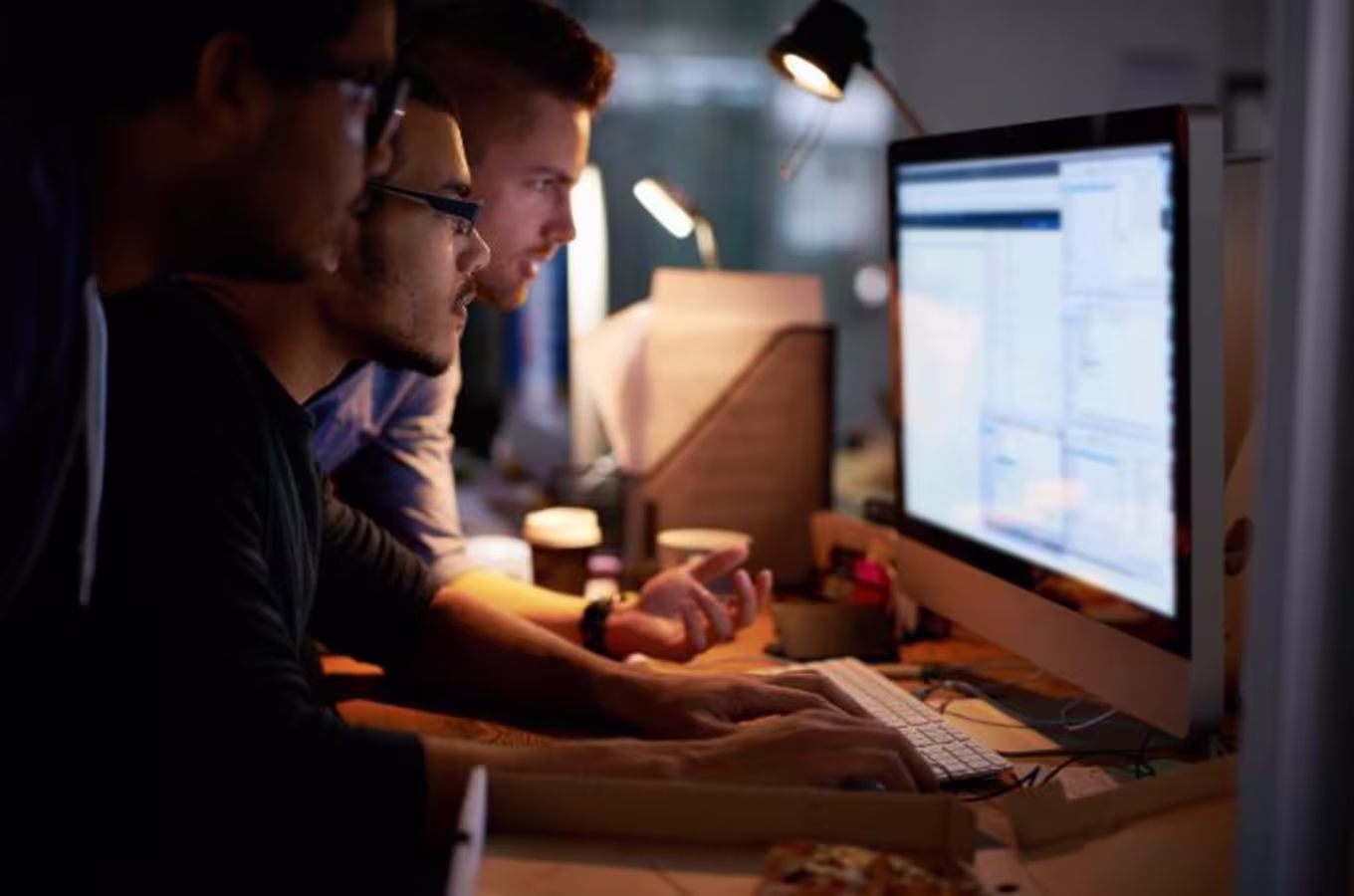three guys in front of a computer