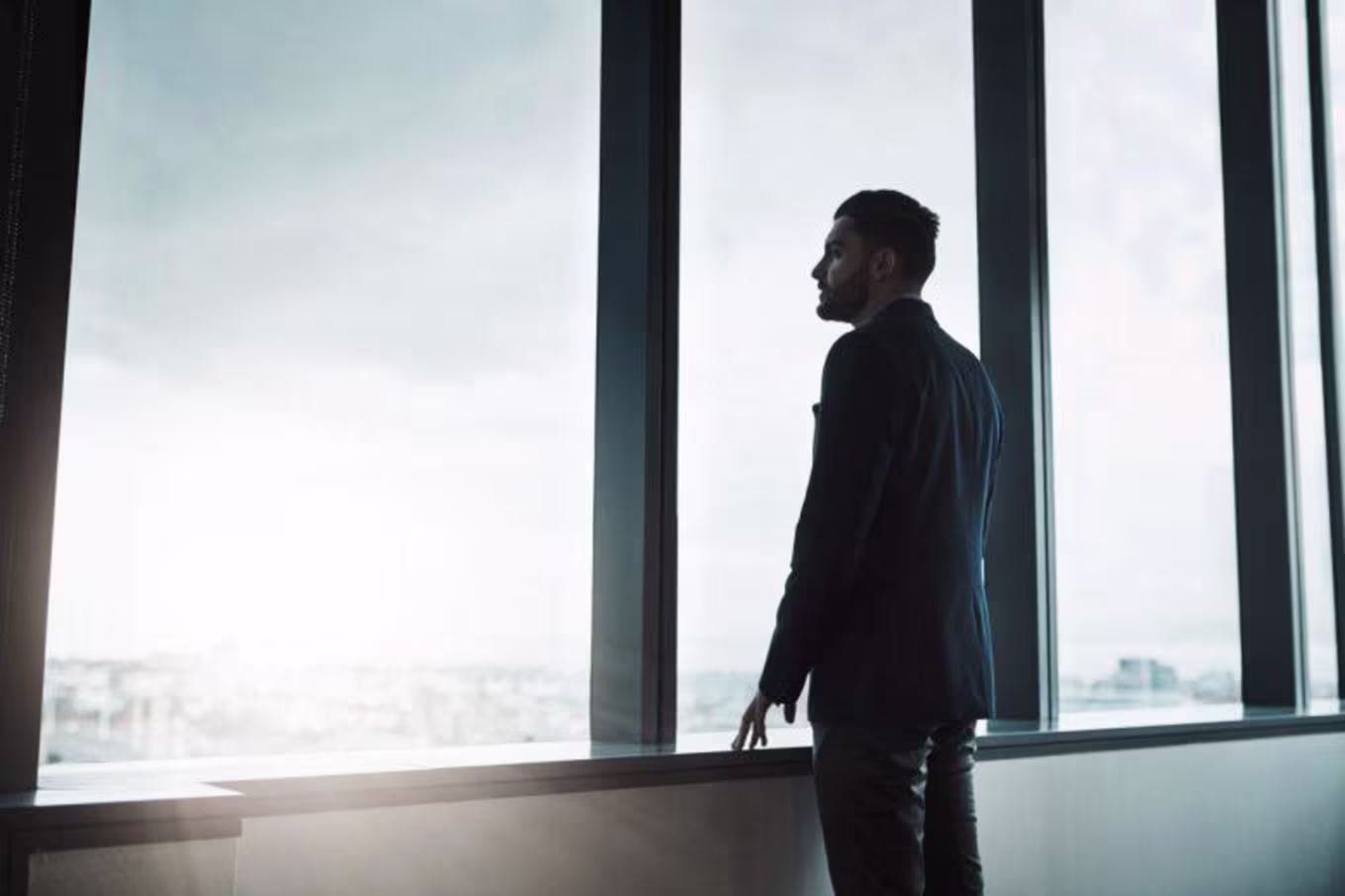 man thinking and looking out of window