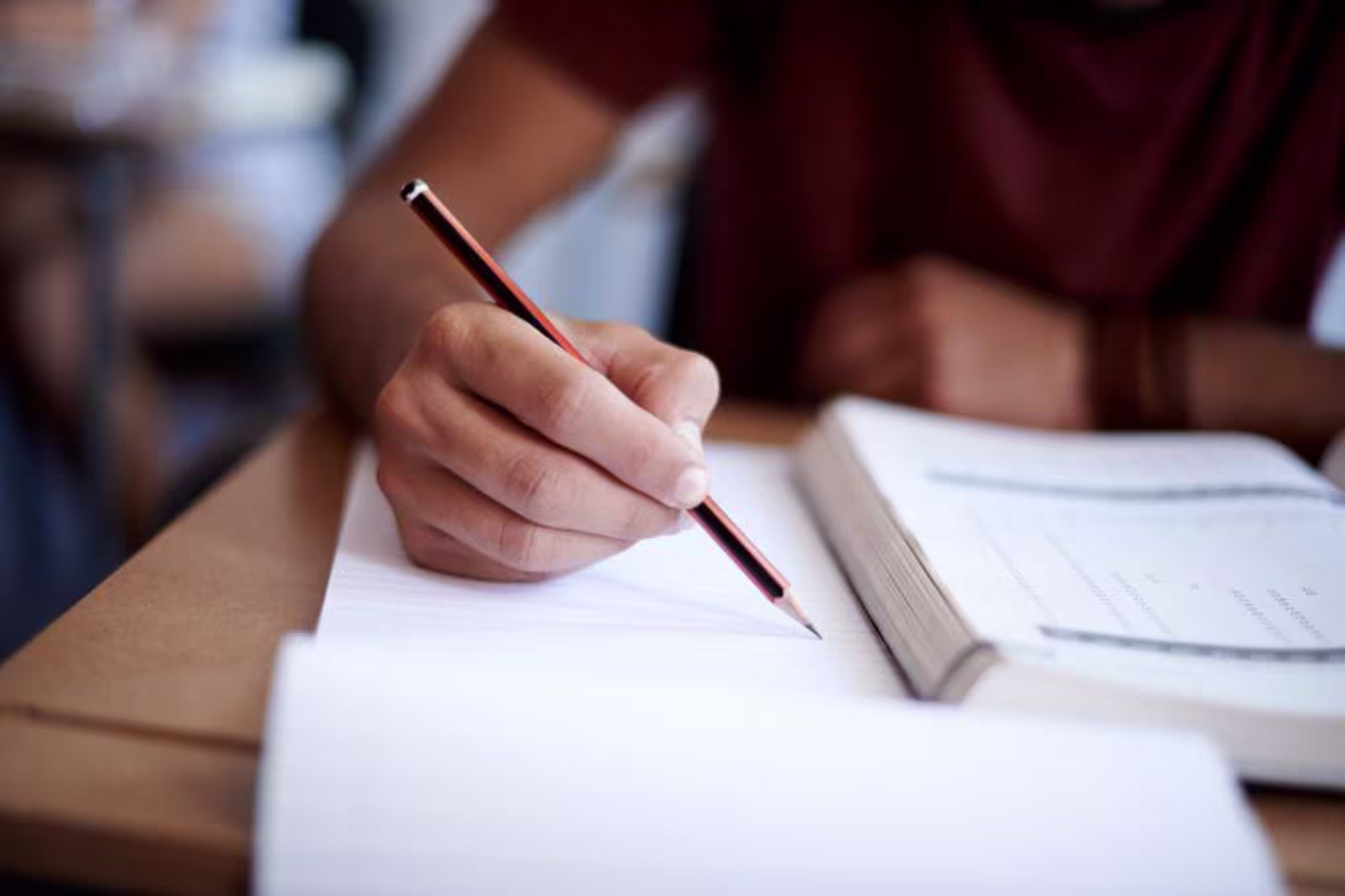 Student taking notes from a textbook