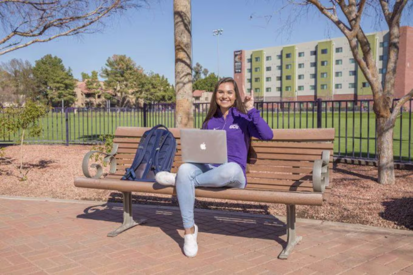 Tatum sitting on a bench on campus