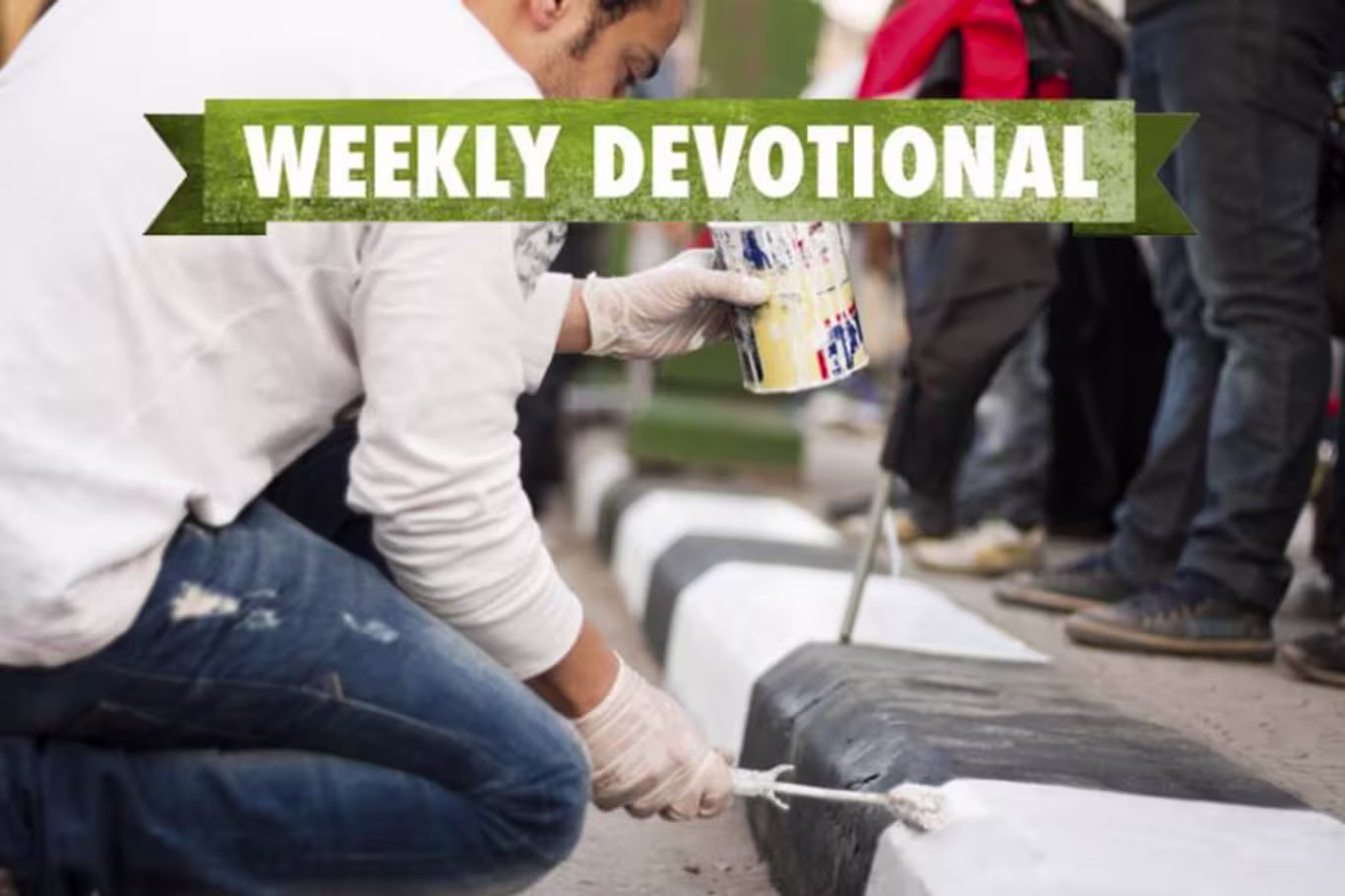 A man painting curbs under the Weekly Devotional banner