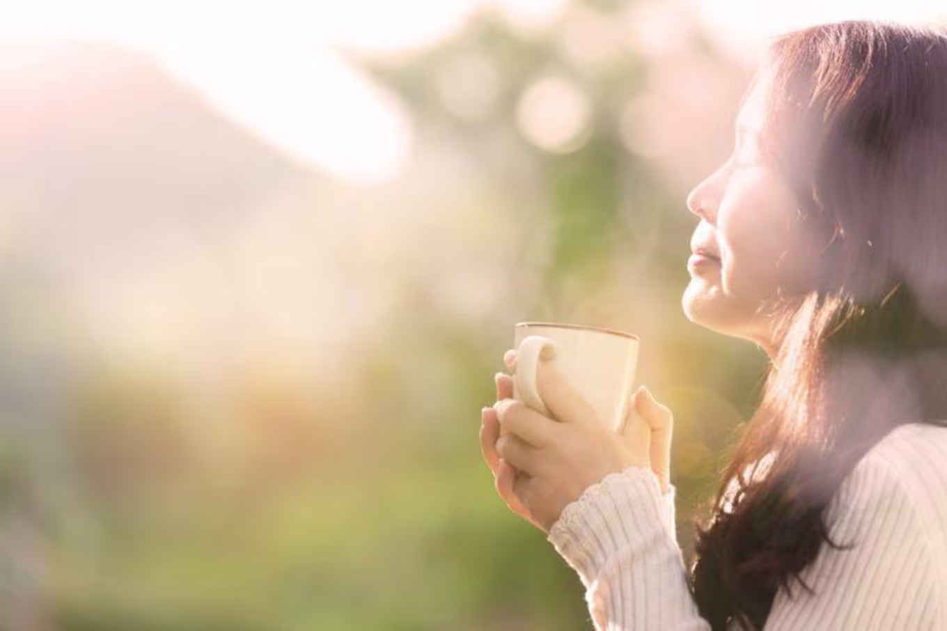woman holding a coffee cup outside